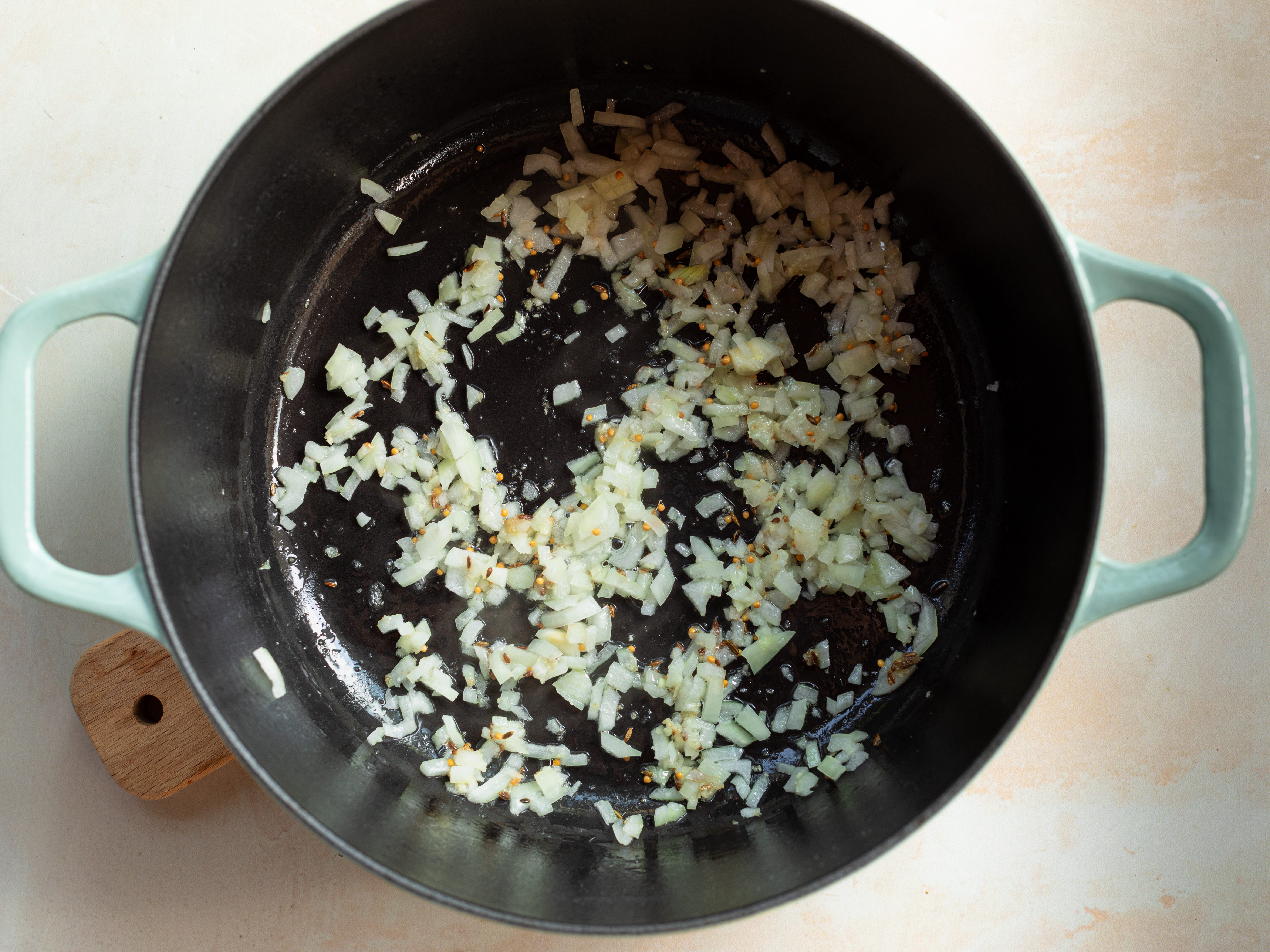 Schritt 2: Die gehackte Zwiebel hinzufügen und anbraten, bis sie golden und leicht gebräunt ist