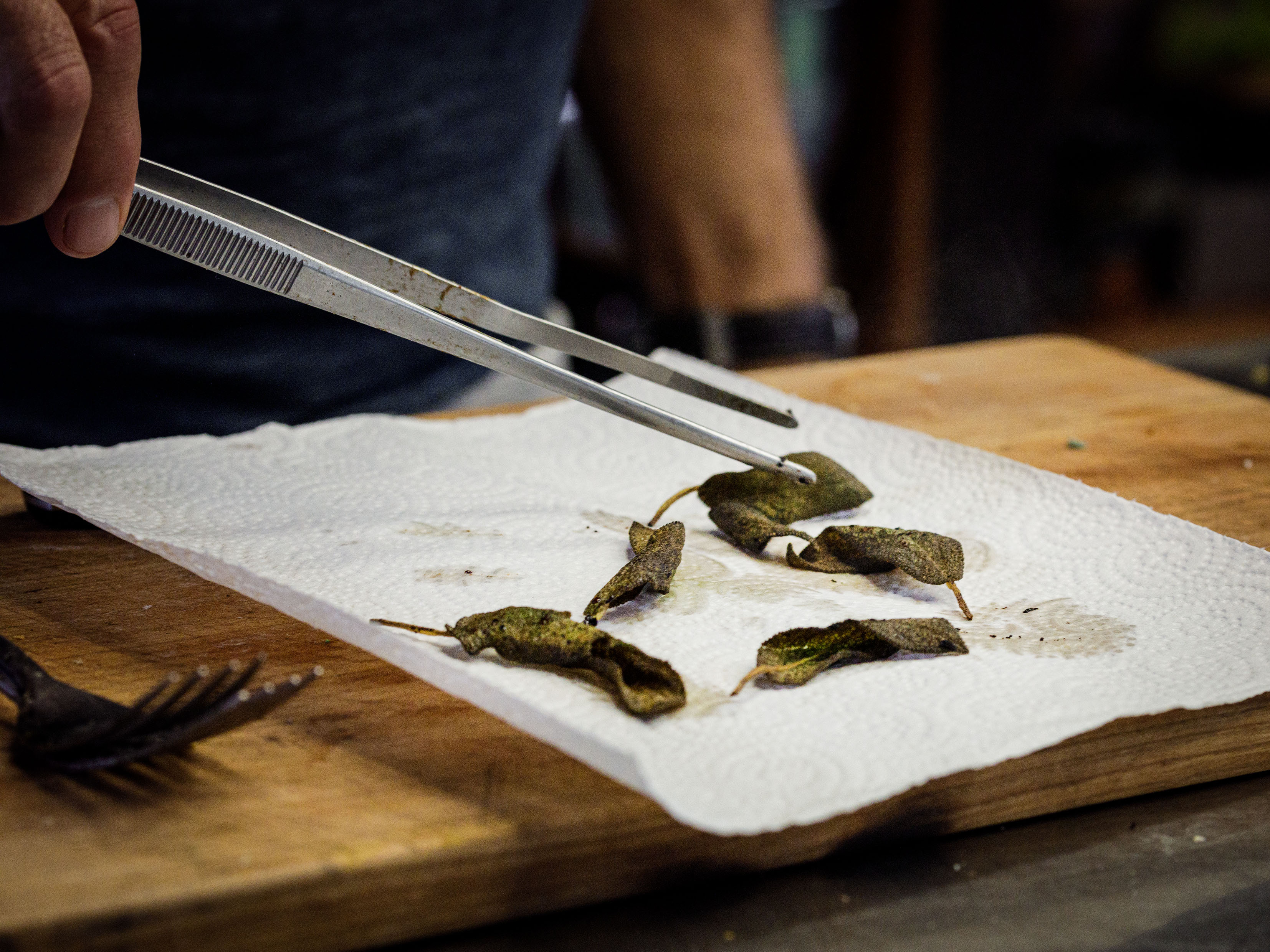 Schritt 3: Die Salbeiblätter mit einem Schaumlöffel auf einen mit Küchenpapier ausgelegten Teller geben