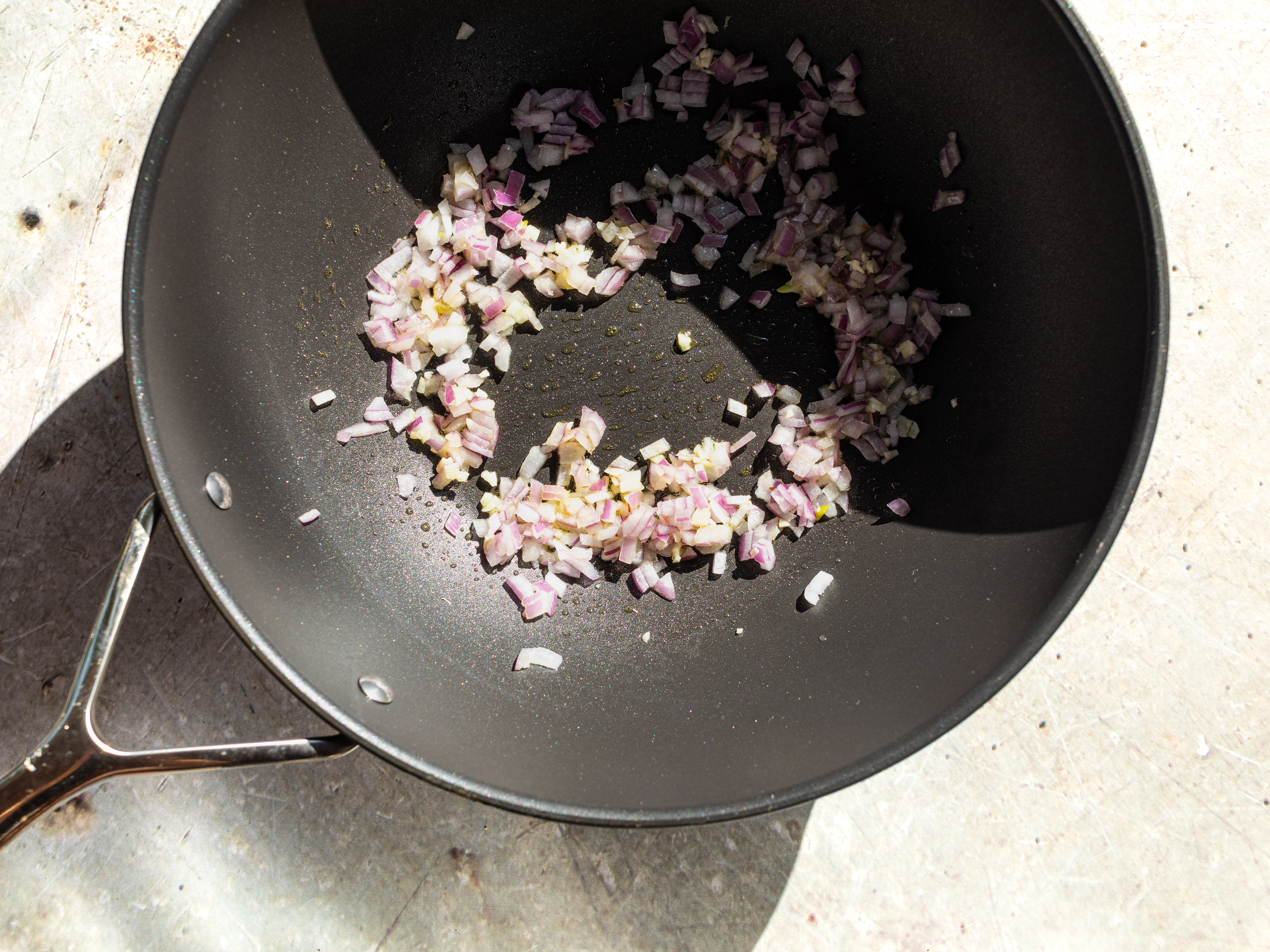 Schritt 3: In einer Pfanne Olivenöl erhitzen, zwiebeln und Knoblauch darin anbraten, bis sie weich sind