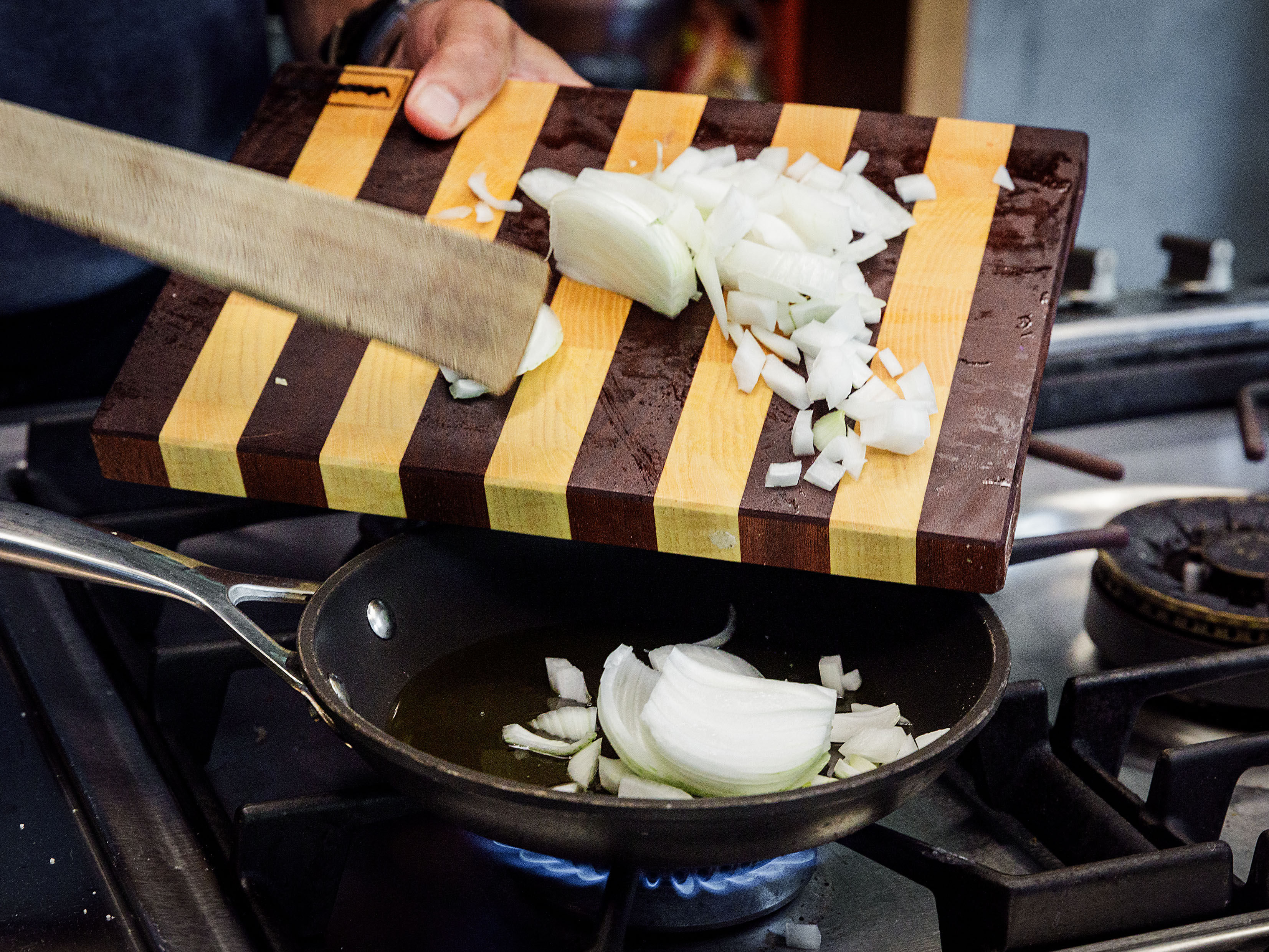 Schritt 2: Etwas Olivenöl in einer Pfanne bei starker Hitze erhitzen und die Zwiebeln darin unter gelegentlichem Rühren zirka 5 Minuten goldbraun braten