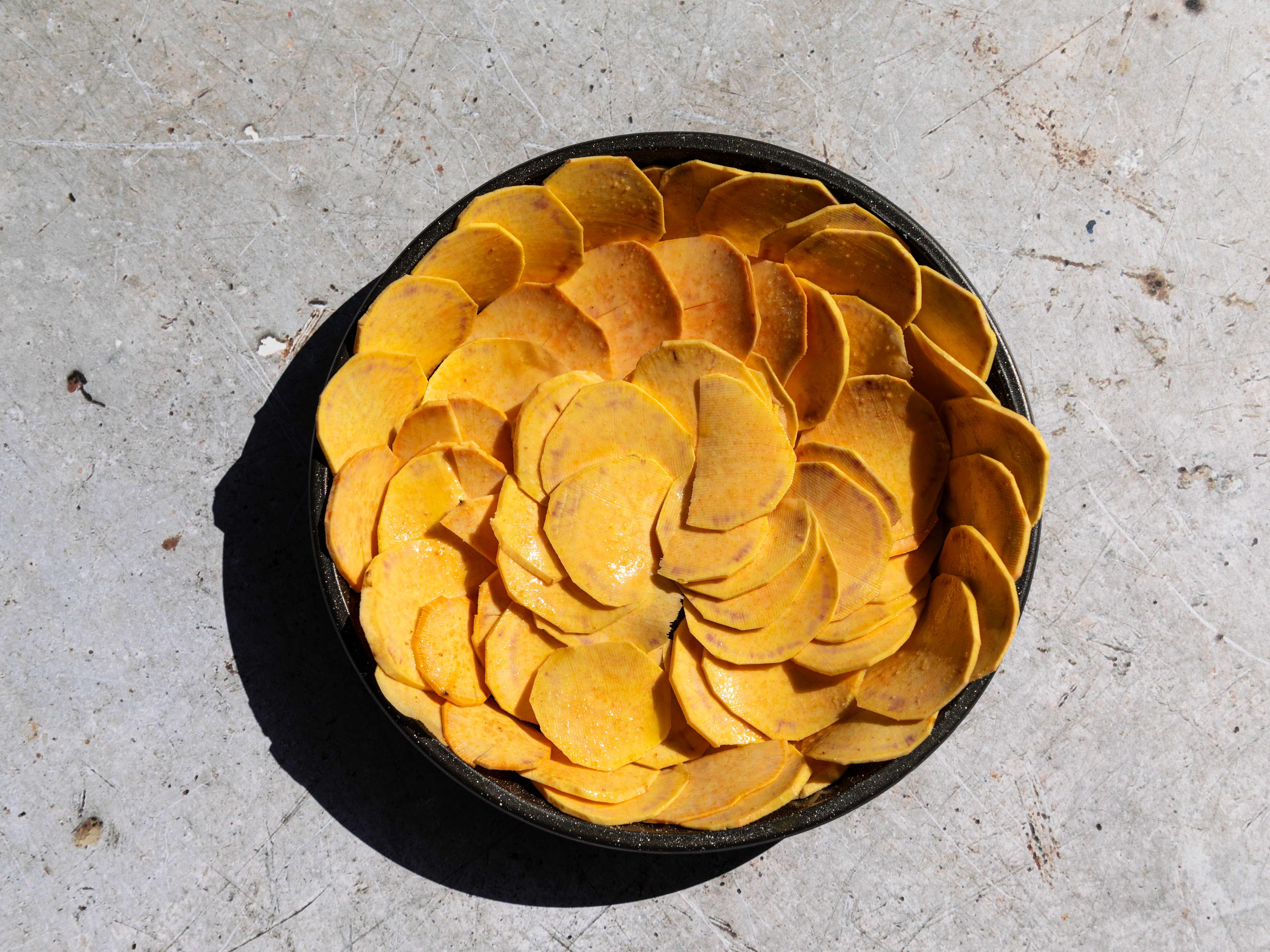 Schritt 1: Die Süsskartoffelscheiben gleichmässig am Boden und an den Seiten der Form auslegen.