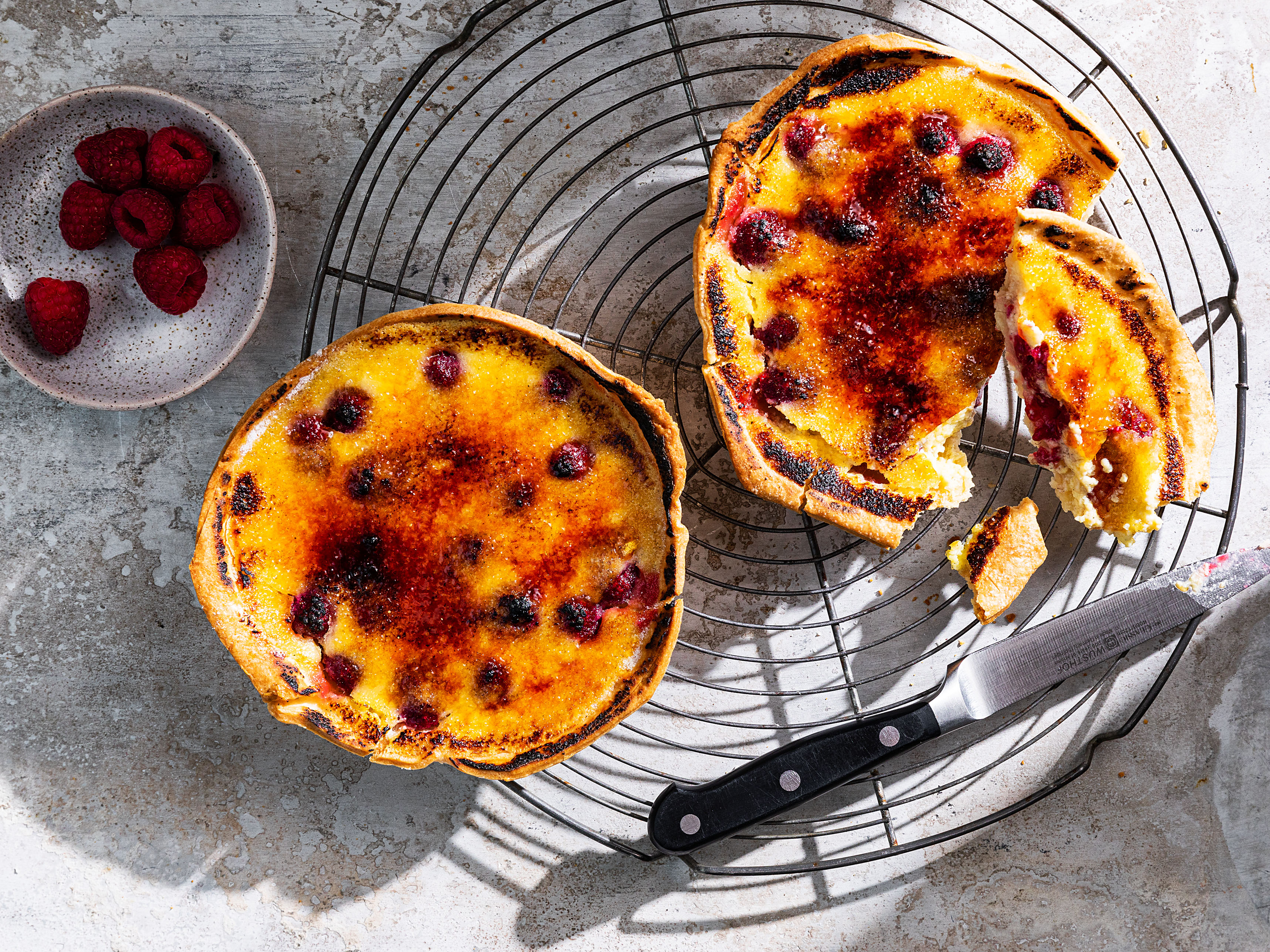 Schritt 5: Zuckerkruste für Vanille-Himbeer Crème brûlée Tartelettes flämmen.