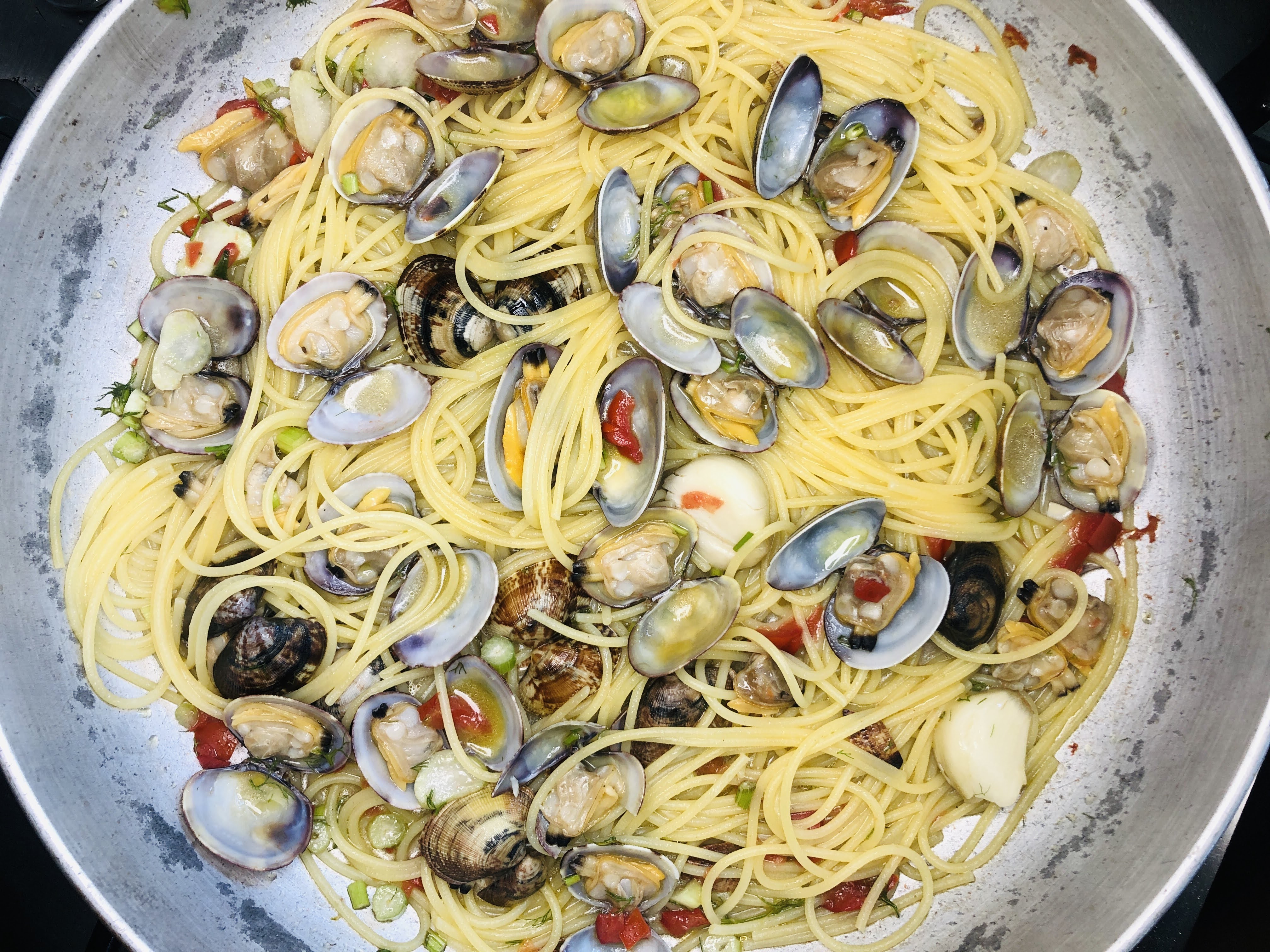 Schritt 4: Die Hälfte der Muscheln auslösen, zusammen mit der anderen Hälfte und dem ausgelaufenen Saft zurück in die Pfanne geben