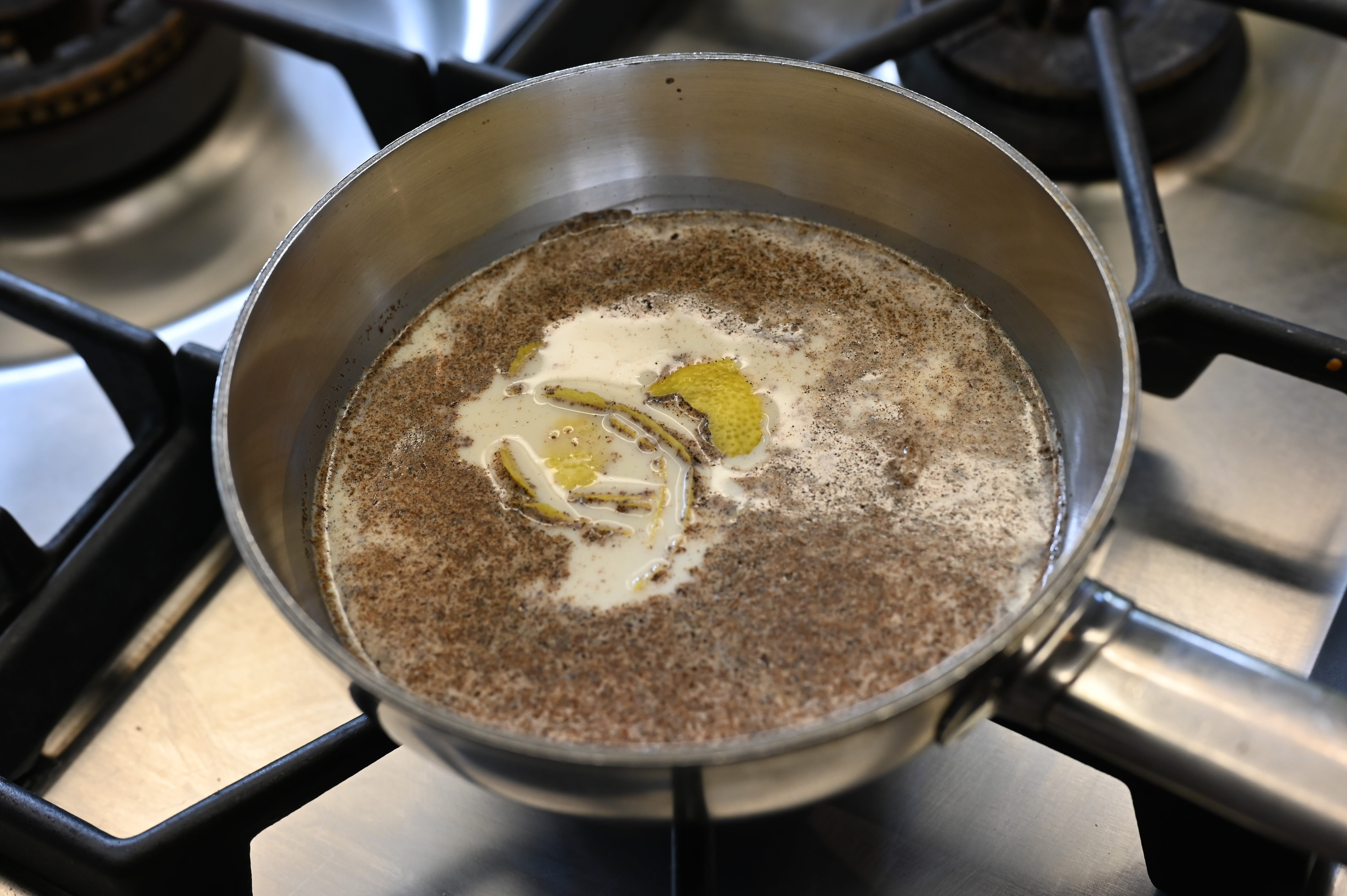 Schritt 2: Milch mit Zucker, Vanille und Zitronenschale langsam aufkochen, bis sich der Zucker aufgelöst hat