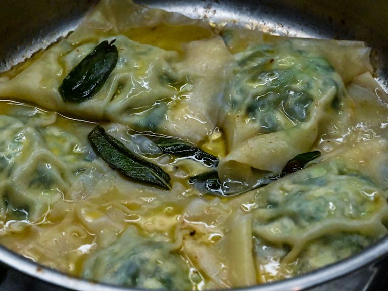 Schritt 4: Die Wonton-Ravioli mit dem Schaumlöffel herausheben und in der Butter wenden Schritt 4: Die Wonton-Ravioli mit dem Schaumlöffel herausheben und in der Butter wenden