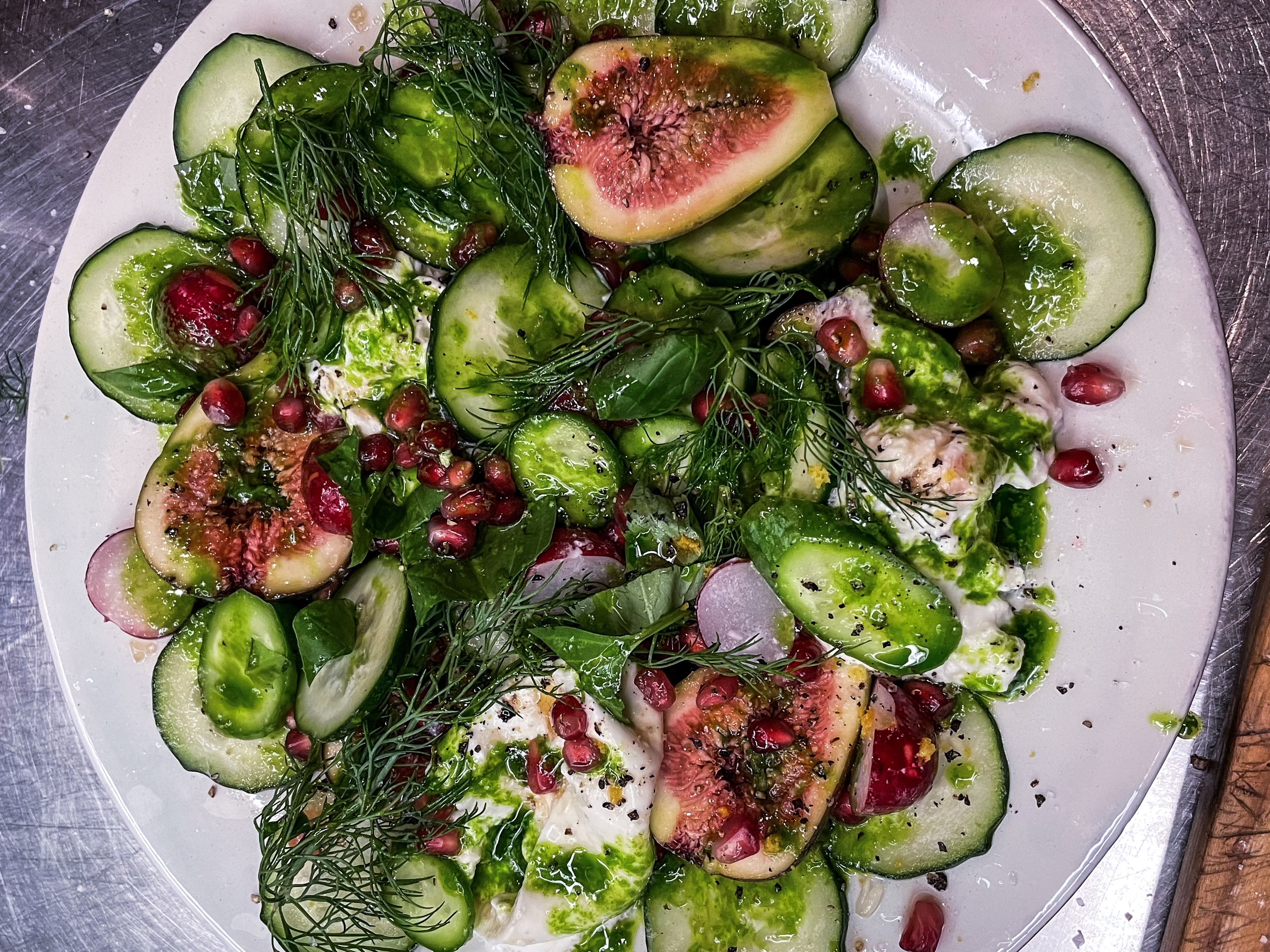 Schritt 2:  Feigen-Grantapfel-Salat mit Burrata, Gurken und Kräuteröl anrichten.