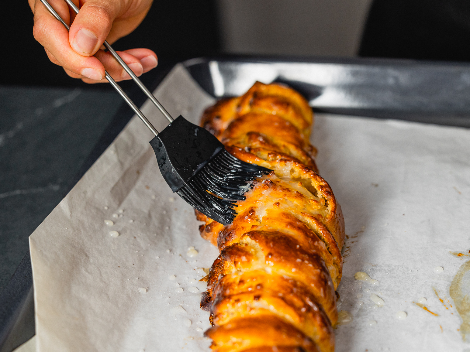Schritt 2: Den Puderzucker mit der Milch zu einem Guss verrühren und den noch warmen Kokos-Zopf damit bestreichen.  