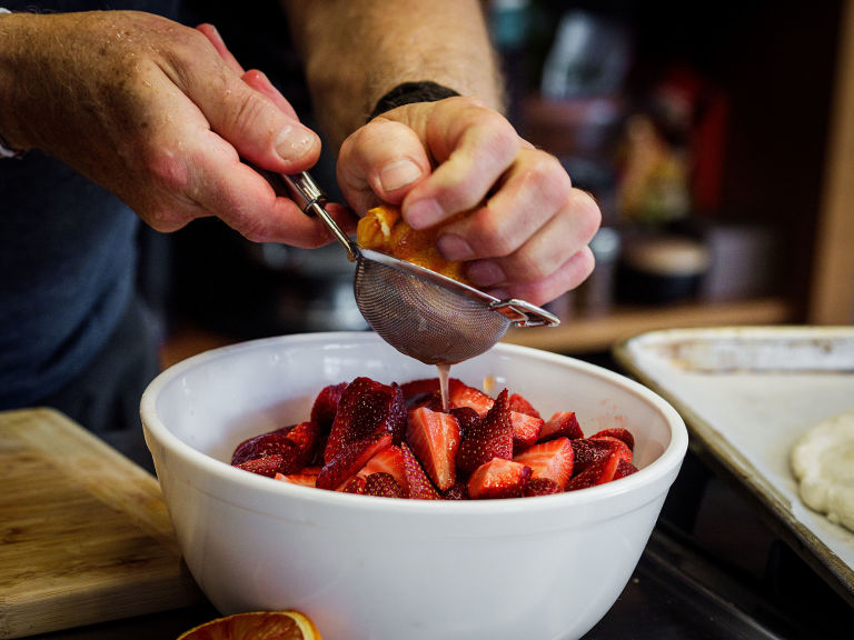 Schritt 2: Die Erdbeeren in einer Schüssel mit dem Orangensaft, 40 Milliliter Grand Marnier und 2 Esslöffel Puderzucker vermengen