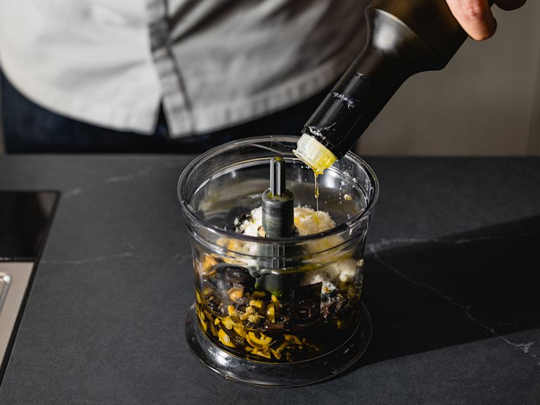 Schritt 1: Die gehackten Oliven, den gehackten Knoblauch, die gehackten Kapern, die gerösteten Zedernkerne, den geriebenen Parmesan und das Olivenöl in einen Mixer oder eine Küchenmaschine geben Schritt 1: Die gehackten Oliven, den gehackten Knoblauch, die gehackten Kapern, die gerösteten Zedernkerne, den geriebenen Parmesan und das Olivenöl in einen Mixer oder eine Küchenmaschine geben