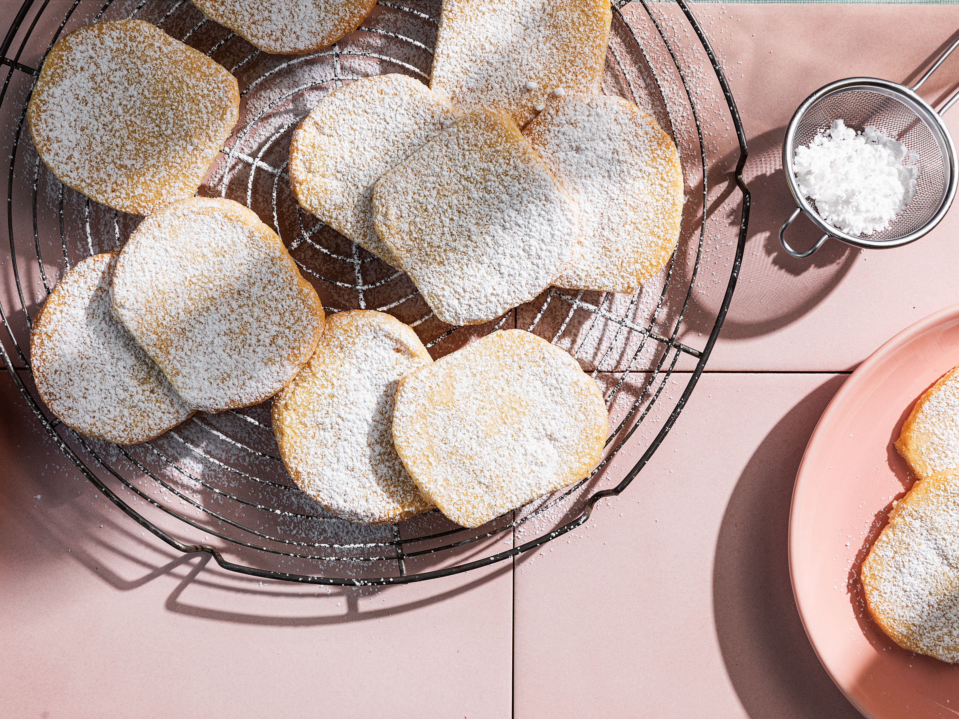 Schritt 3:  Die noch warmen Biscuits grosszügig mit dem restlichen Puderzucker bestäuben und auf einem Gitterrost vollständig auskühlen lassen.