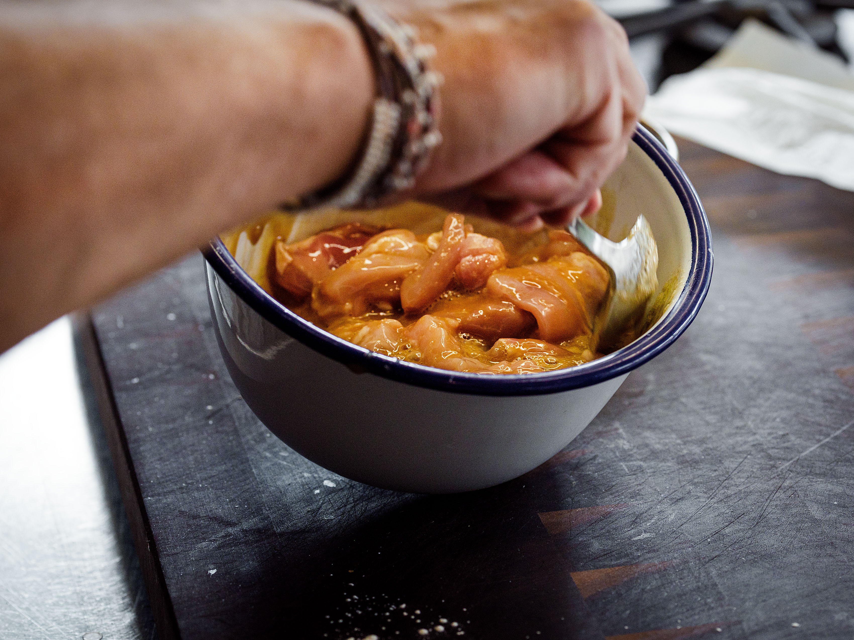 Schritt 1: Die Pouletstücke dazugeben und mit den Fingern gründlich mit der Marinade mischen.