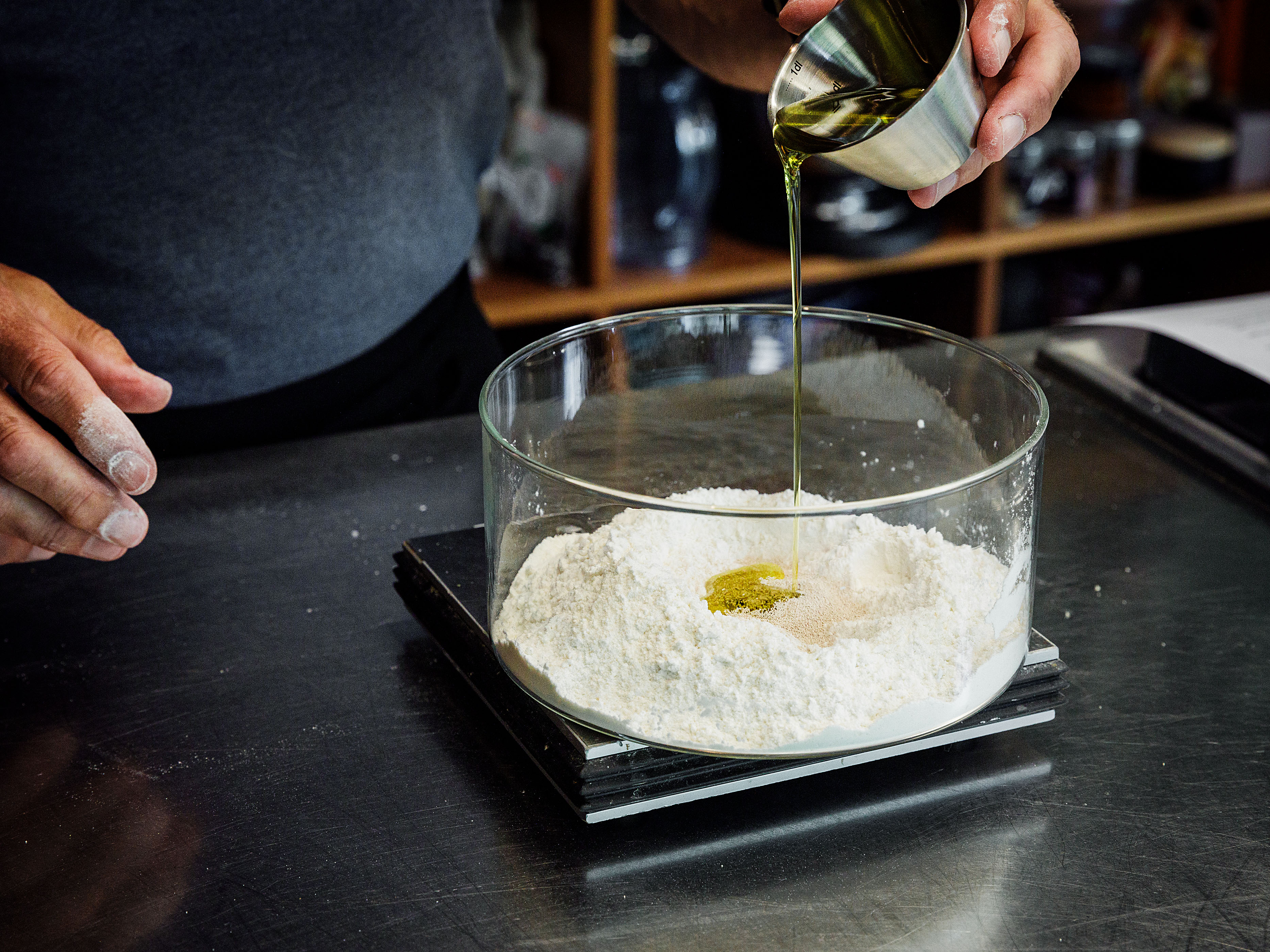 Schritt 1: In der Mitte eine Vertiefung machen, 150 ml warmes Wasser und das Olivenöl hineingeben