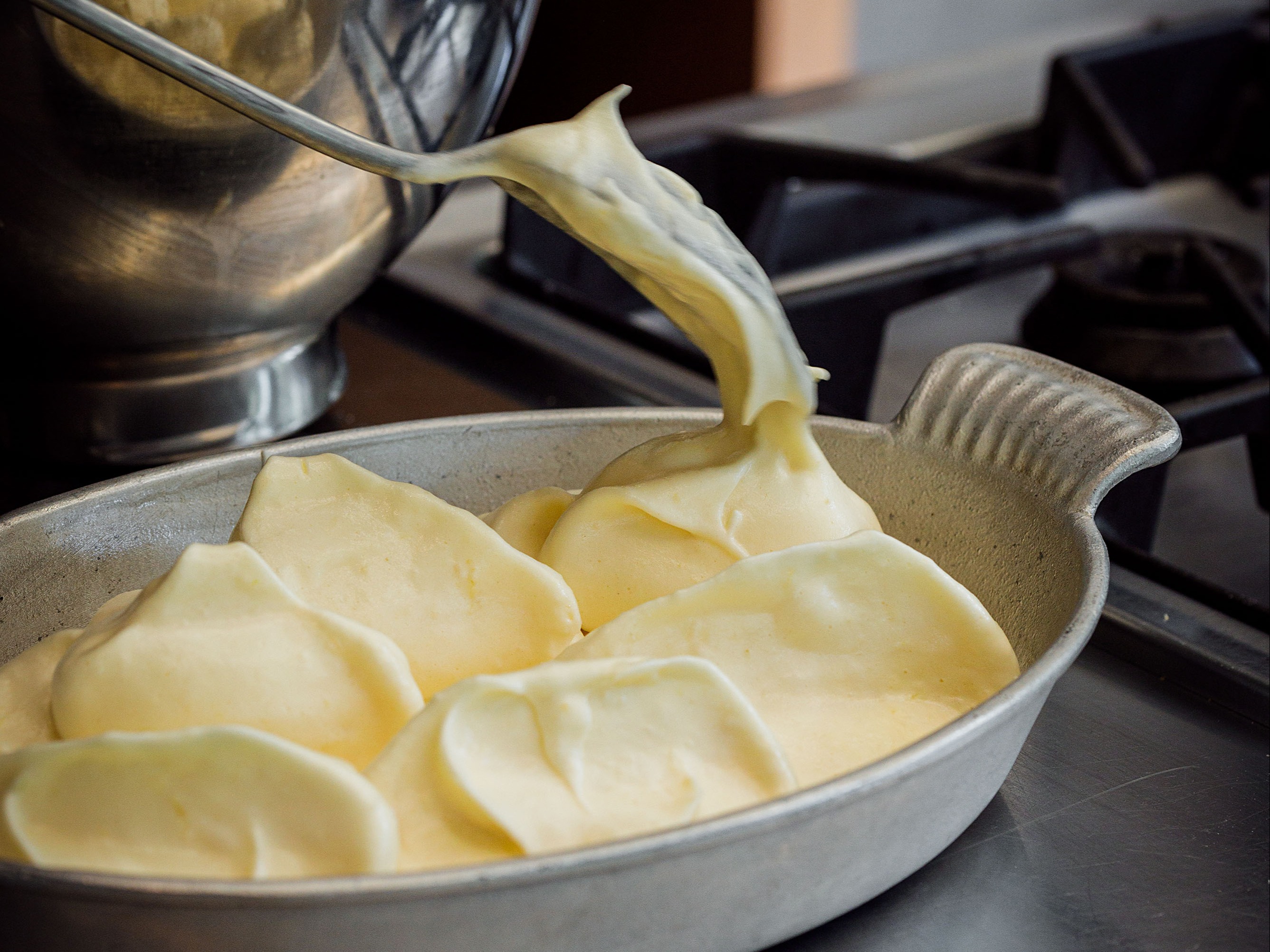Schritt 2: Grosse Nocken in die Auflaufform auf den Milchspiegel in Form einer Hügelkette platzieren