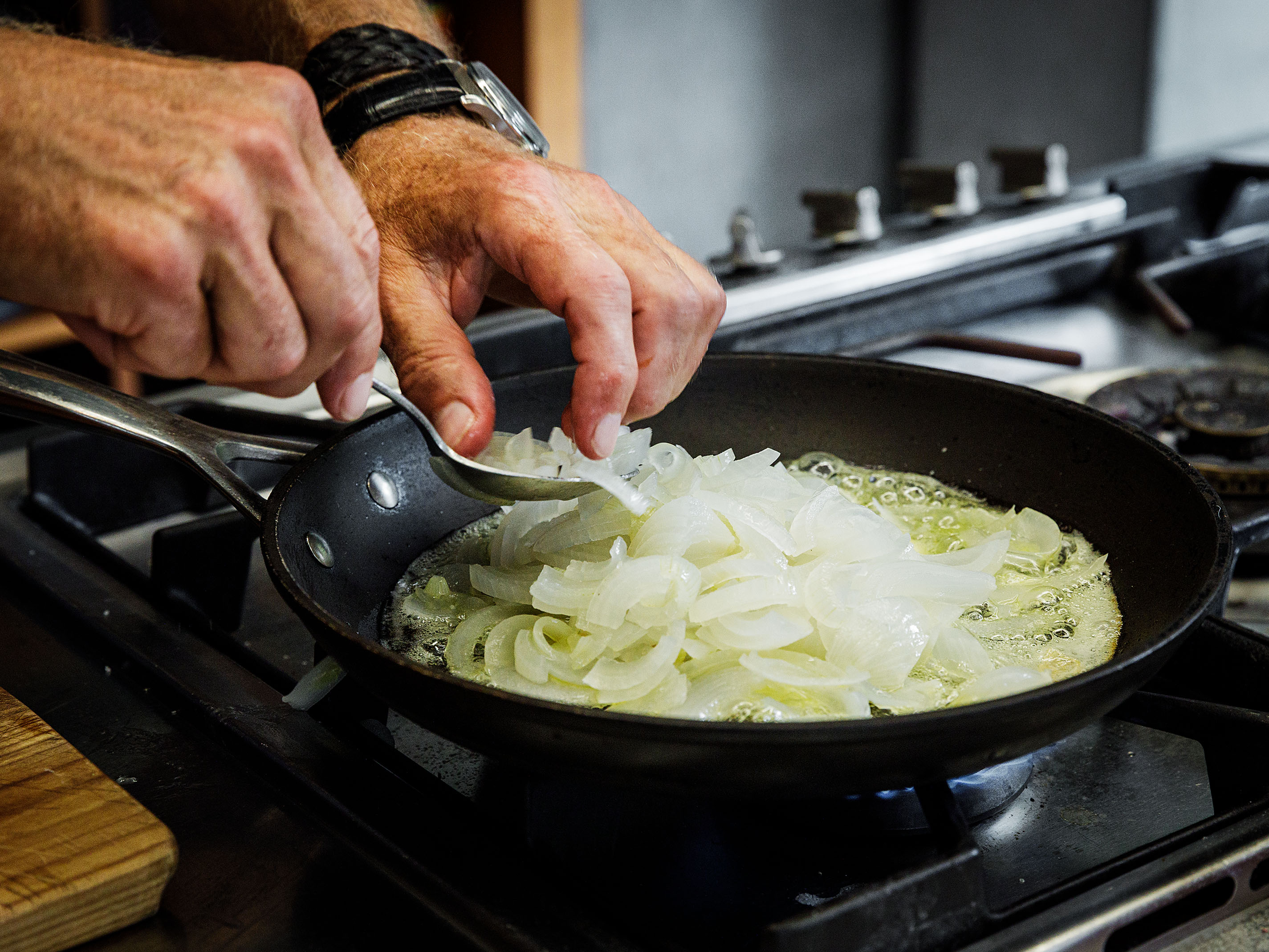 Schritt 3: Das Innere der Zwiebeln grob hacken, in Butter und mit den Kräutern zugedeckt 20 Minuten weich dünsten, bis sie karamellisieren
