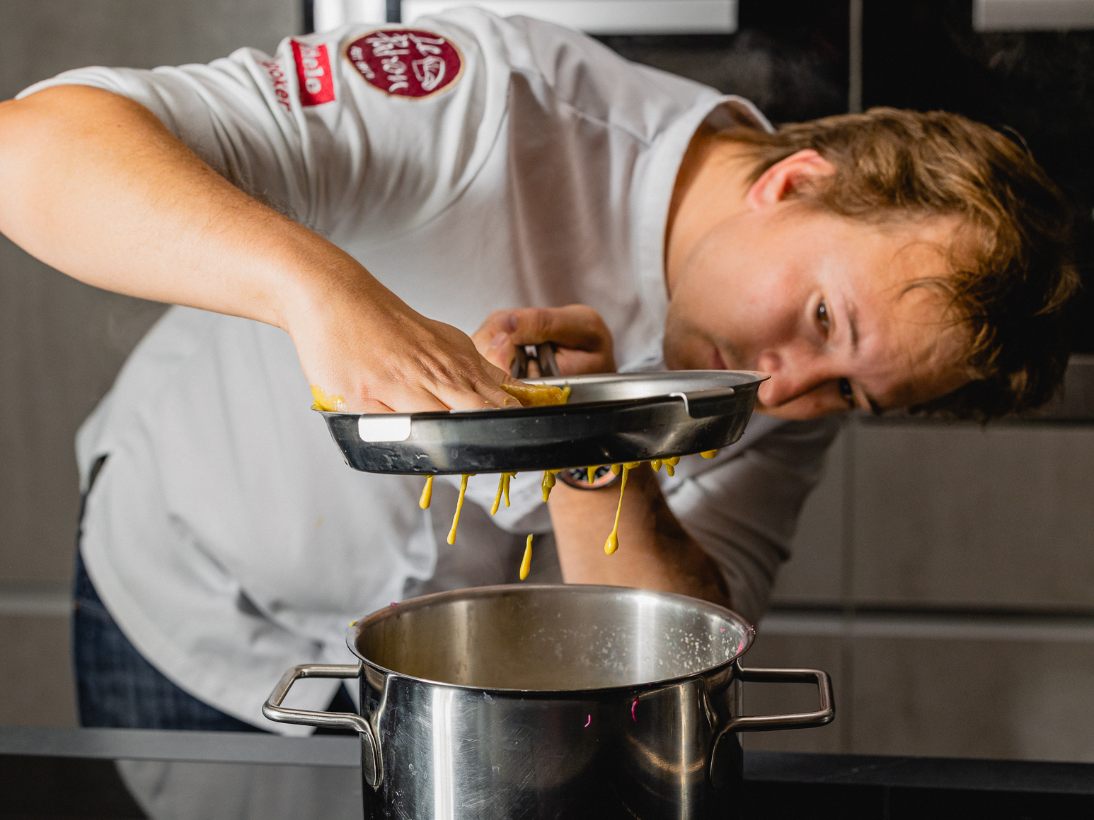 Schritt 2: 2. Den Teig portionsweise durch ein Spätzlesieb ins kochende Wasser geben.  
