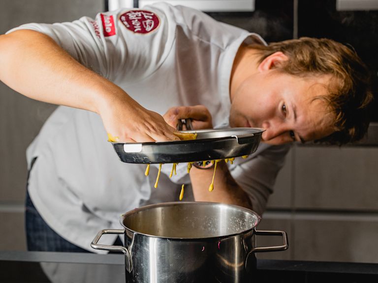 Schritt 2: 2. Den Teig portionsweise durch ein Spätzlesieb ins kochende Wasser geben. Schritt 2: 2. Den Teig portionsweise durch ein Spätzlesieb ins kochende Wasser geben.