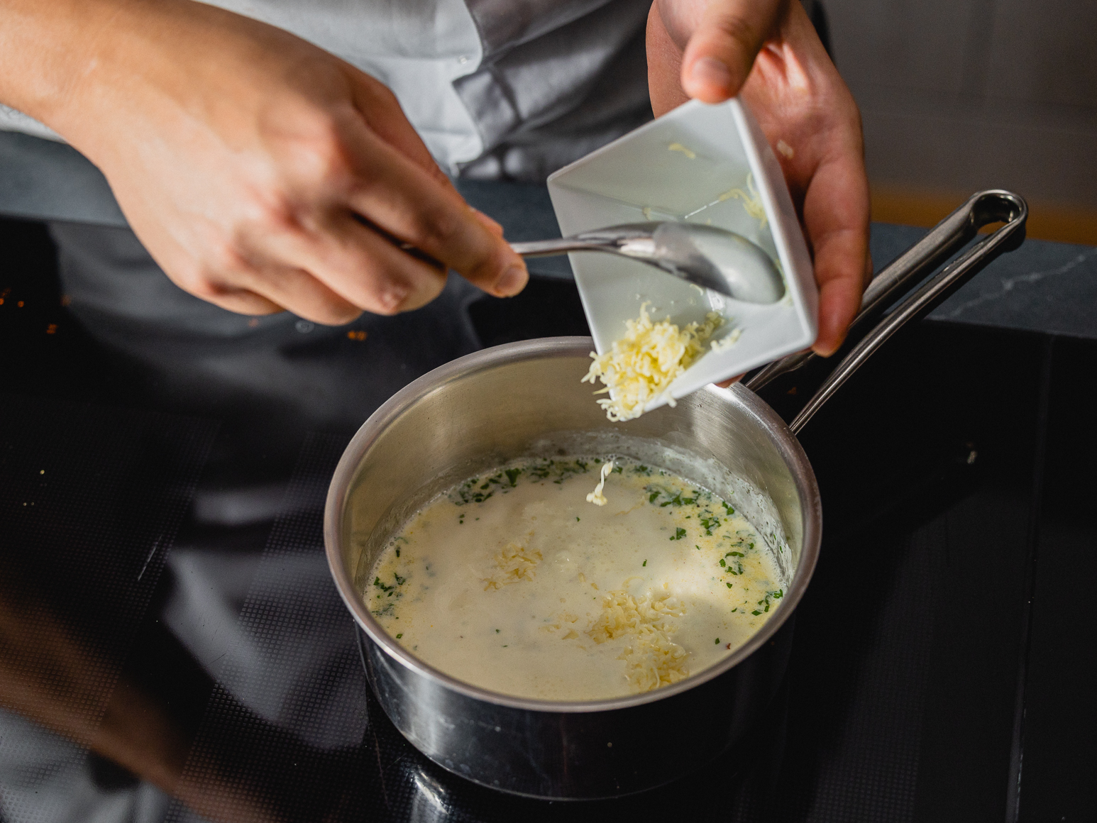 2. Kurz aufkochen lassen, dann die Hälfte vom Käse dazugeben und gut durchrühren.  
