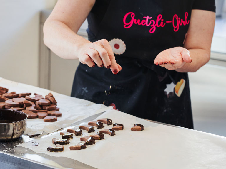 Schritt 3: Die Sablés glasieren und sofort, bevor die Schokolade fest wird, mit Zuckerperlen oder Zuckersternen dekorieren
