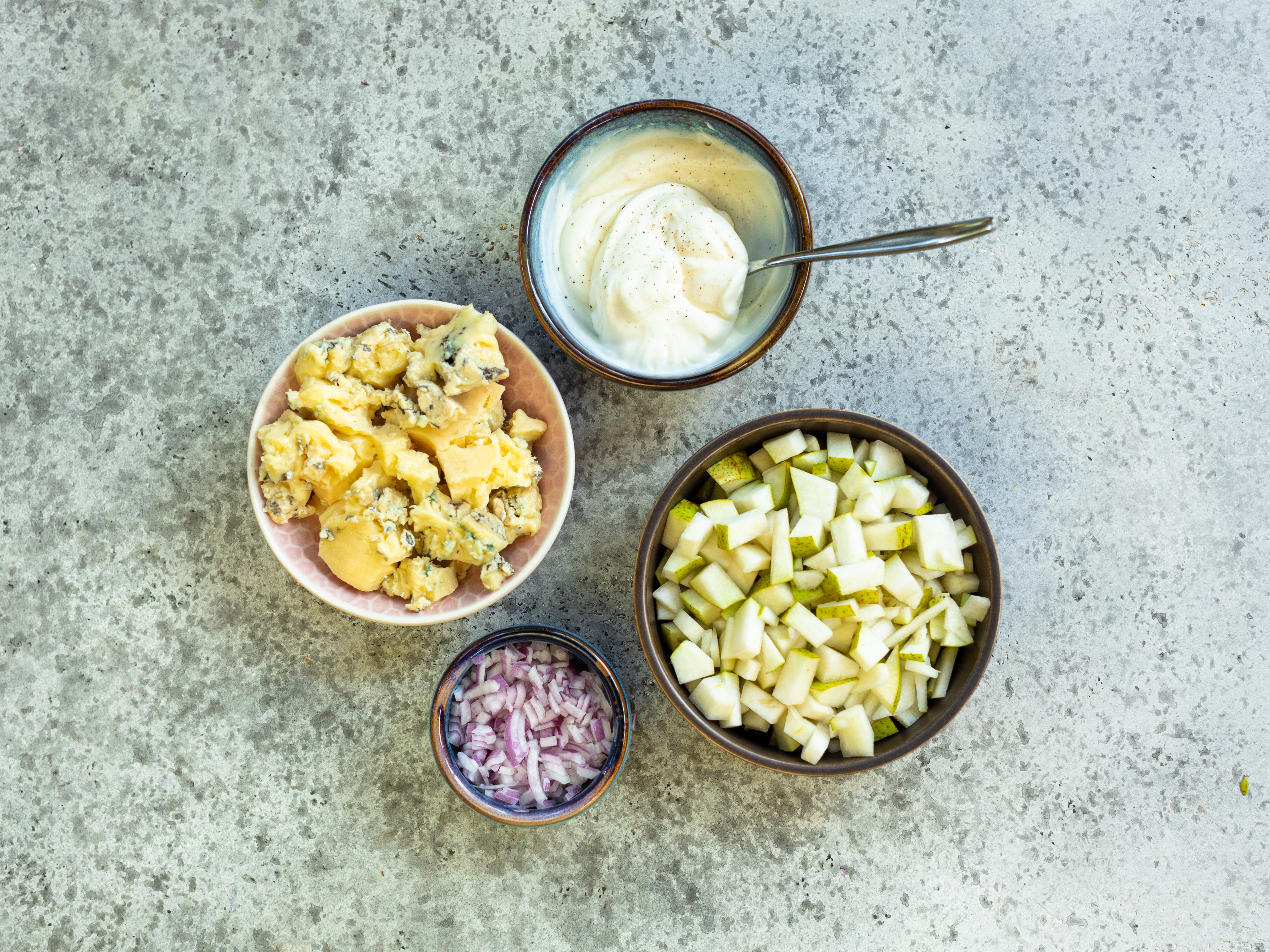 Schritt 2: Die Birnen waschen, wenn gewünscht schälen und in kleine Würfel schneiden, die Zwiebel schälen und ebenso in feine Würfel schneiden, den Gorgonzola-Käse grob zerbröckeln und beiseite stellen
