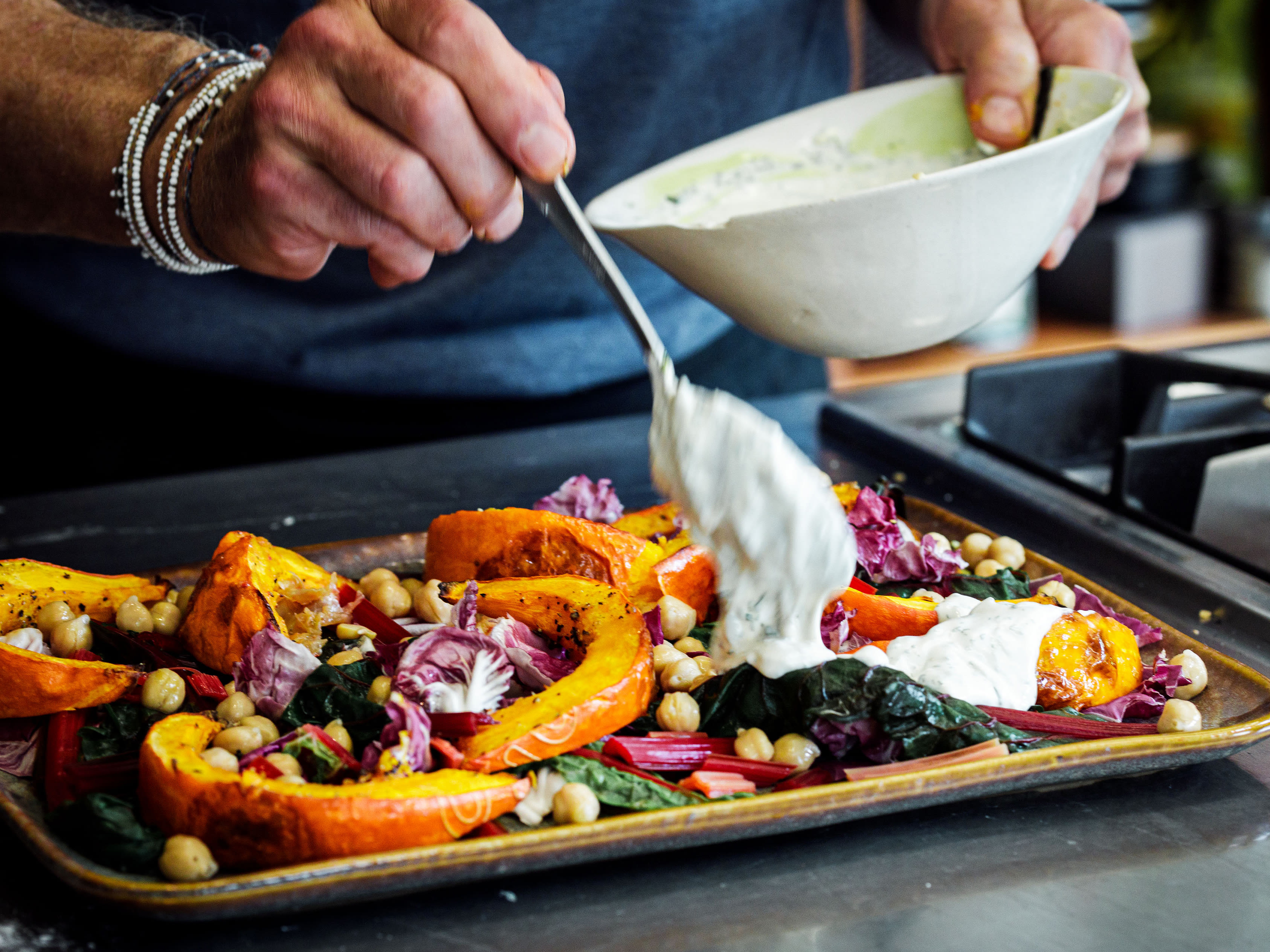 Schritt 4: Röst-Kürbis und Kichererbsen-Salat mit Joghurt-Tahin-Dressing anrichten.