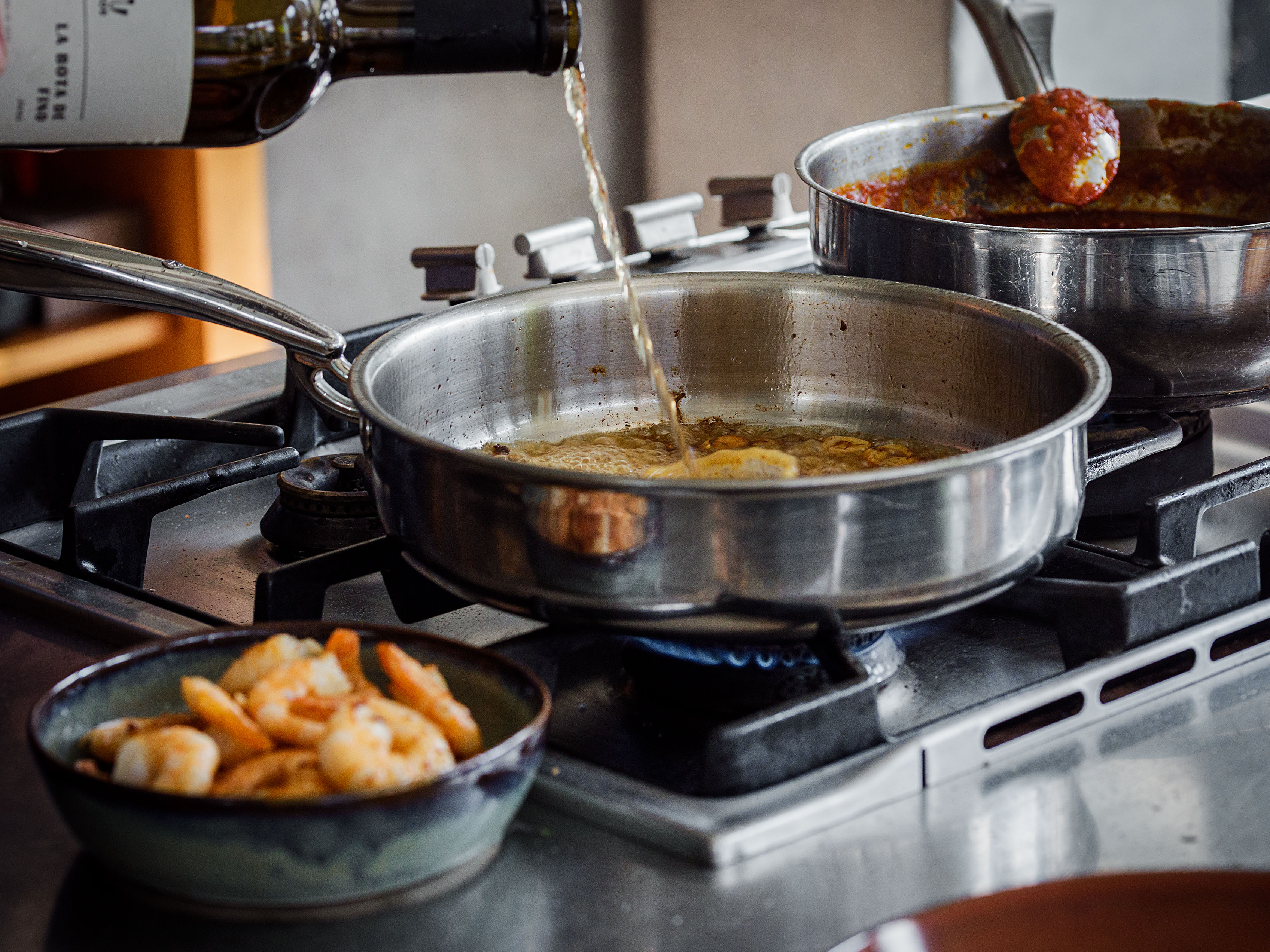 Schritt 2: Petersilie, Sherry, Safran und Shrimps zugeben und den Sherry auf die Hälfte reduzieren