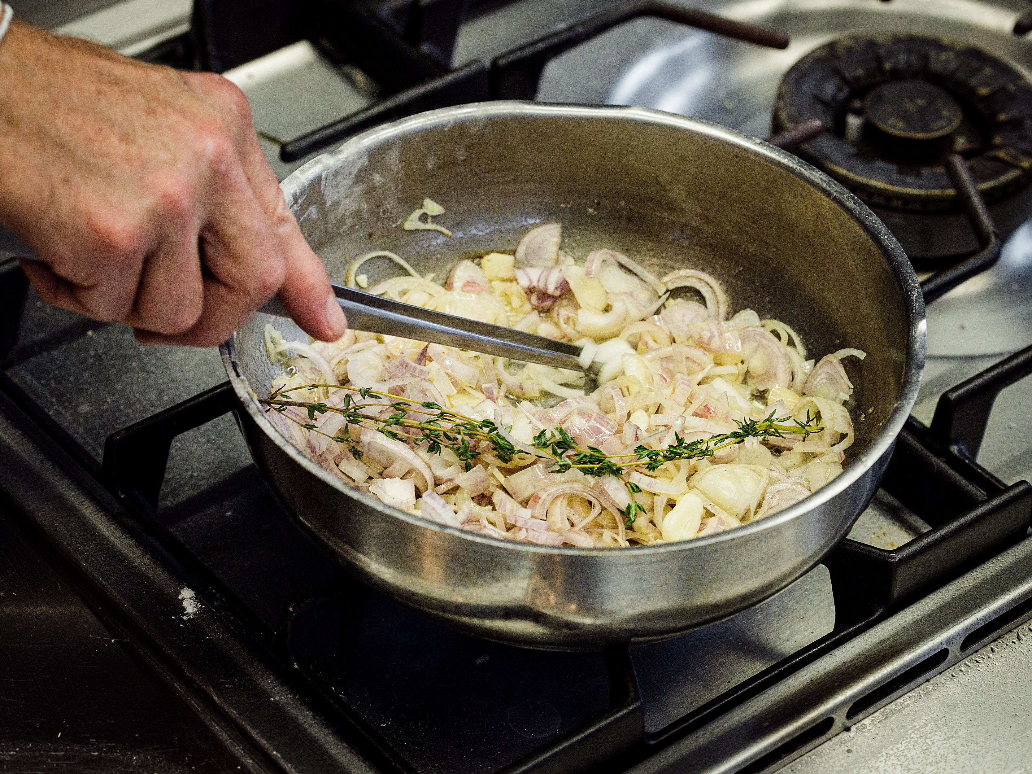 Schritt 1: Die Butter  bei mittlerer Hitze erhitzen, bis sie schäumt. Schalotten, Knoblauch und Thymian in einem Topf mit erhitzten Butter hinzufügen und gelegentlich umrühren
