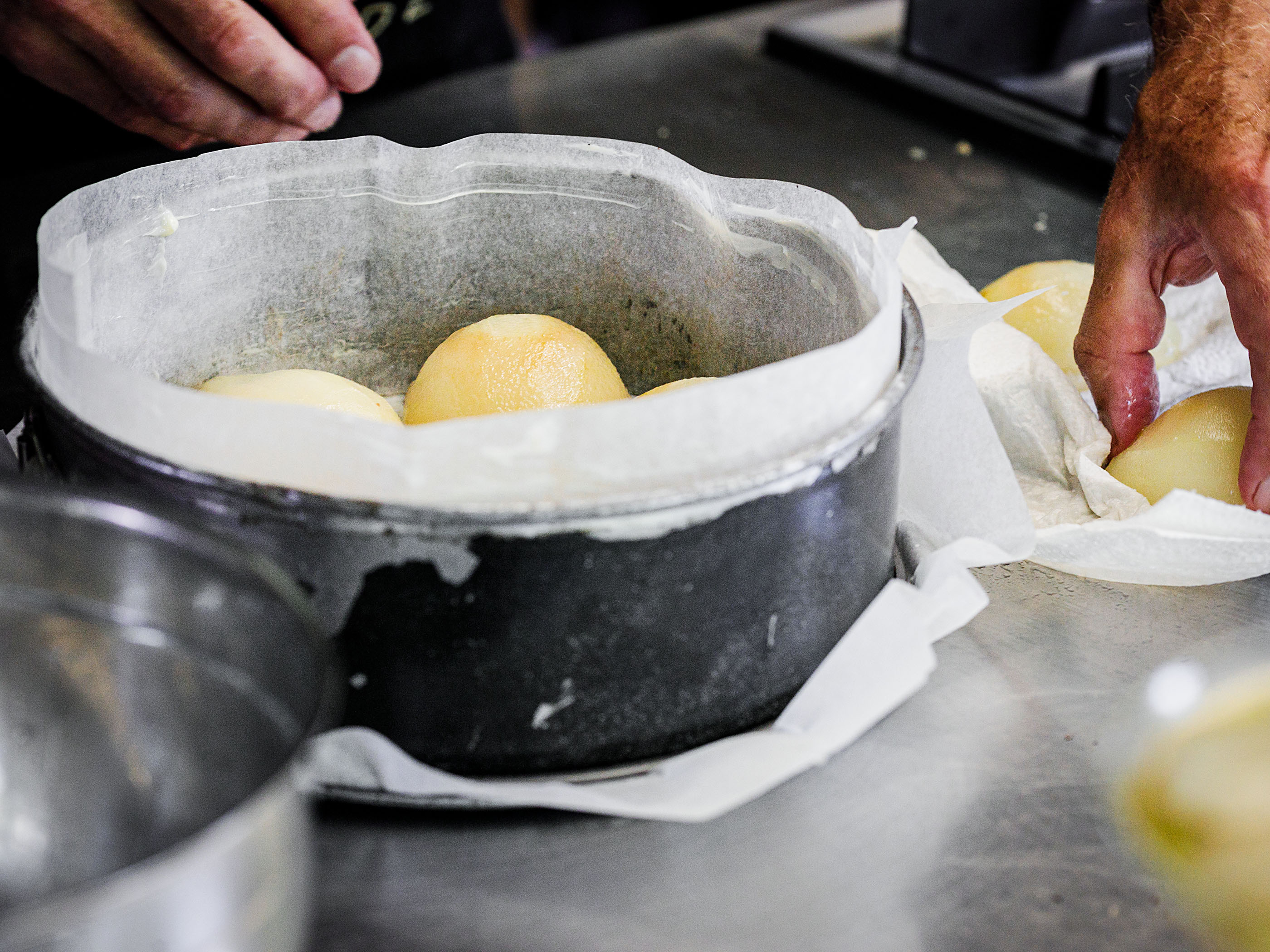 Schritt 2: Die Birnenhälften mit der Schnittseite nach unten auf den Haselnüssen in der Form arrangieren