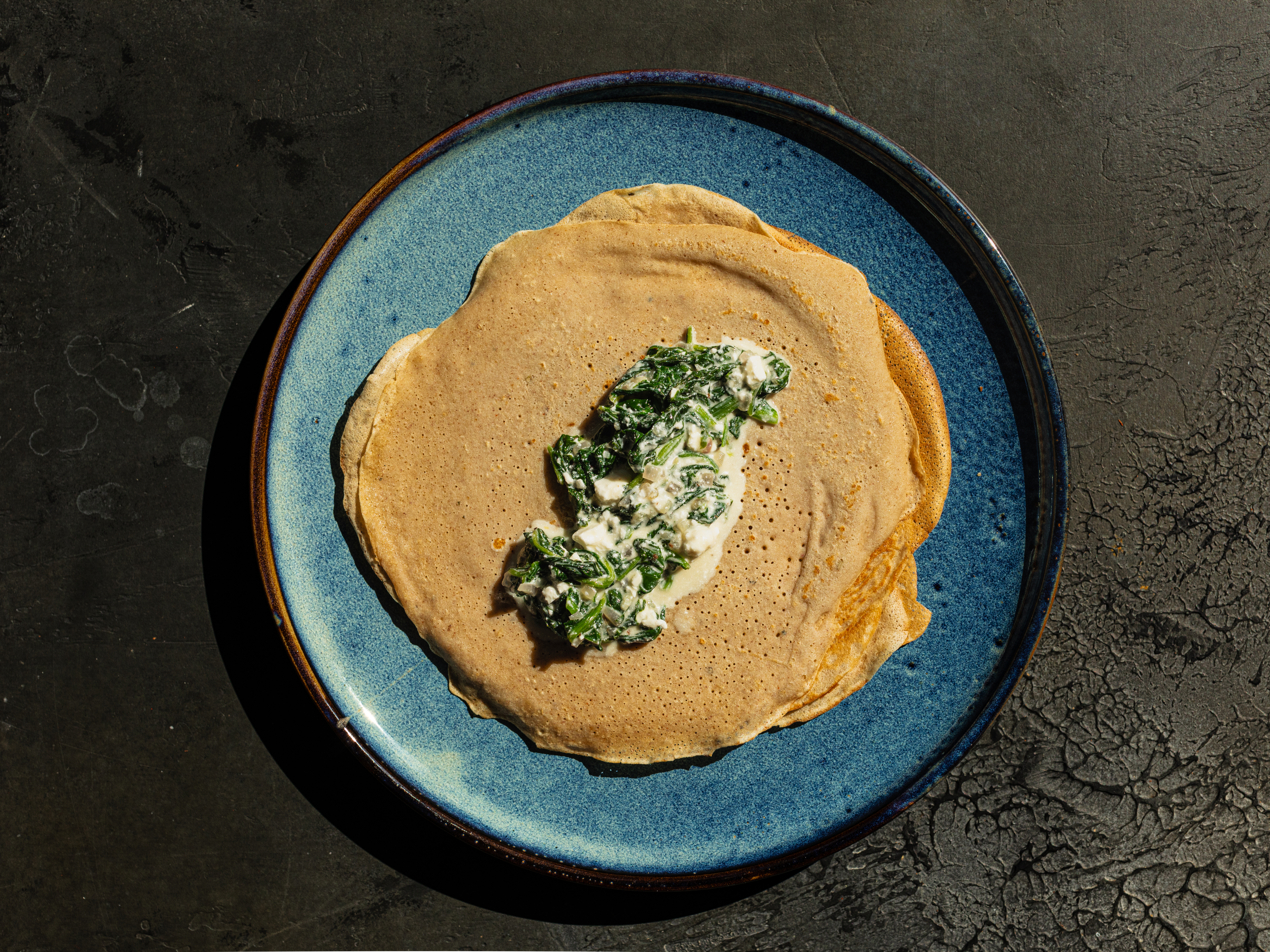 Schritt 4: Die Crêpes auf Teller legen und mit der Spinat-Feta-Mischung belegen und aufrollen