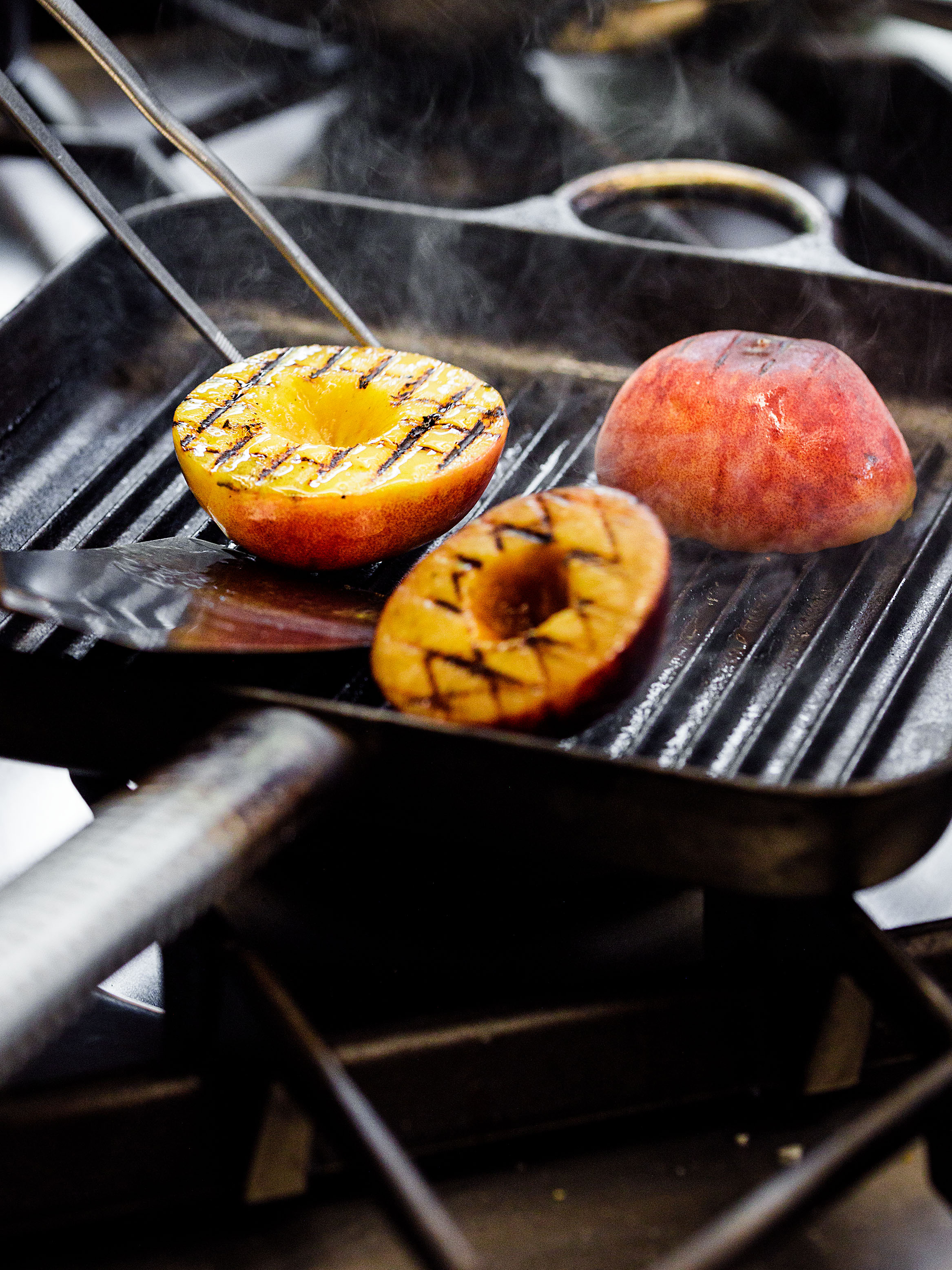 Zubereitung der Pfirsich für einen Linsensalat mit grillierten Pfirsichen, Zuchiniblüten und Stracciatella
