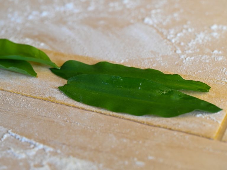 Schritt 3: Die Bärlauchblätter dekorativ zwischen zwei Pastabahnen legen