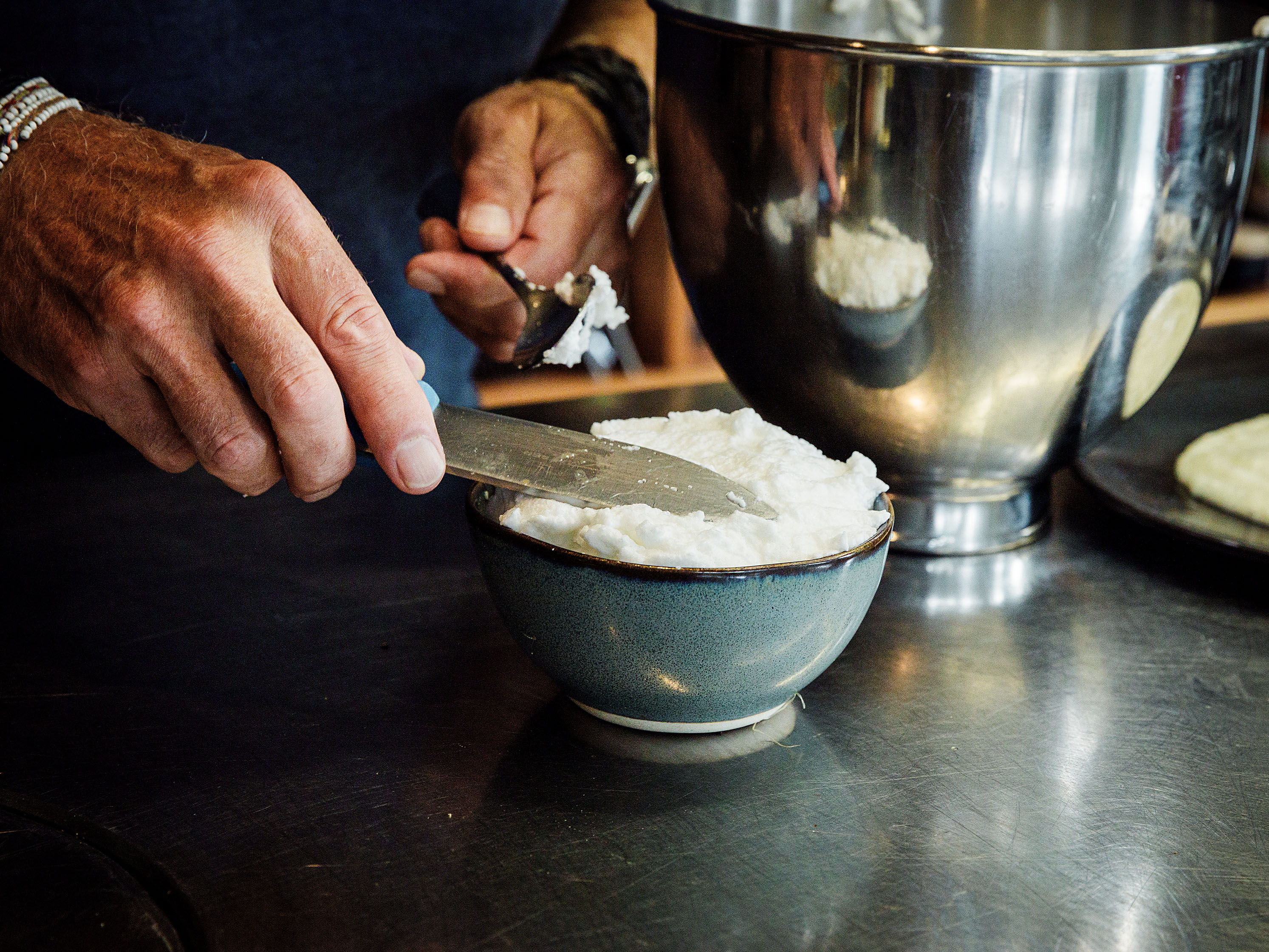 Schritt 2: Die Hälfte des geschlagenen Eiweisses bis zum oberen Rand einfüllen und eine Vertiefung eindrücken, dann je ein Eigelb vorsichtig hineingeben und mit dem restlichen Eiweiss bedecken