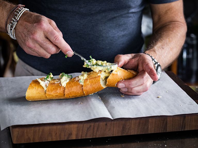 Schritt 2: Die Knoblauch-Butter-Mischung grosszügig und gleichmässig zwischen den Scheiben verteilen und die letzten Reste in der Mitte des Brotes verstreichen. Schritt 2: Die Knoblauch-Butter-Mischung grosszügig und gleichmässig zwischen den Scheiben verteilen und die letzten Reste in der Mitte des Brotes verstreichen.