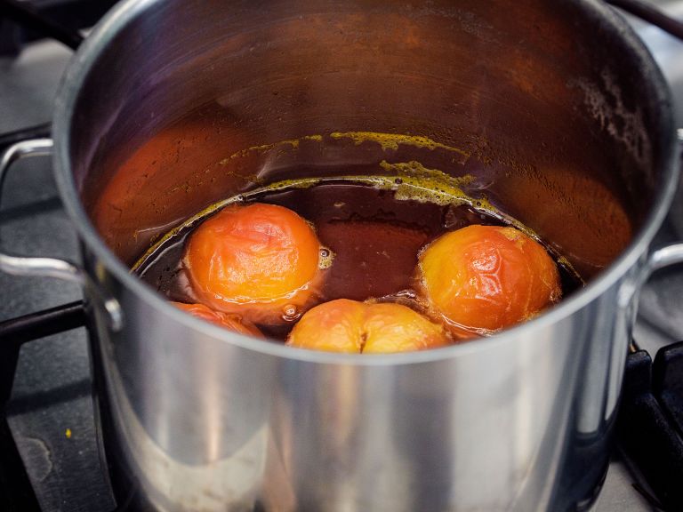 Schritt 2: Pfirsiche zugeben, zum Köcheln bringen und mit einem Teller beschweren, damit sie eintauchen