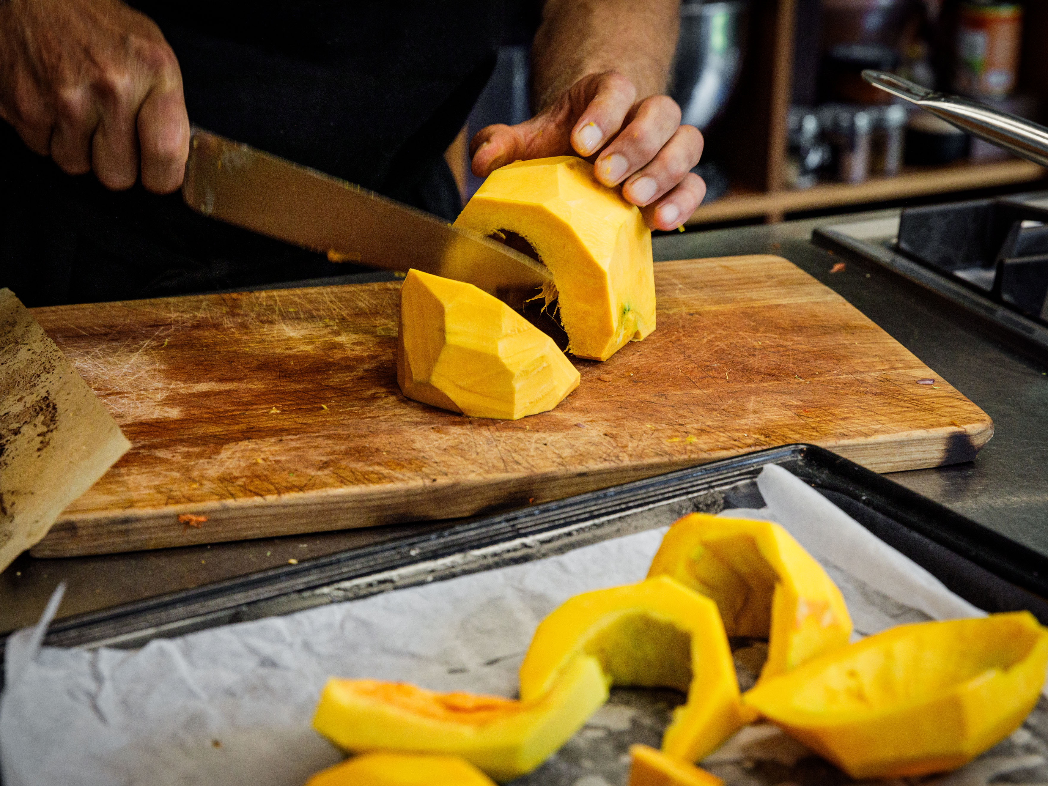 Schritt 1: Kürbis schneiden und auf das Backpapier verteilen