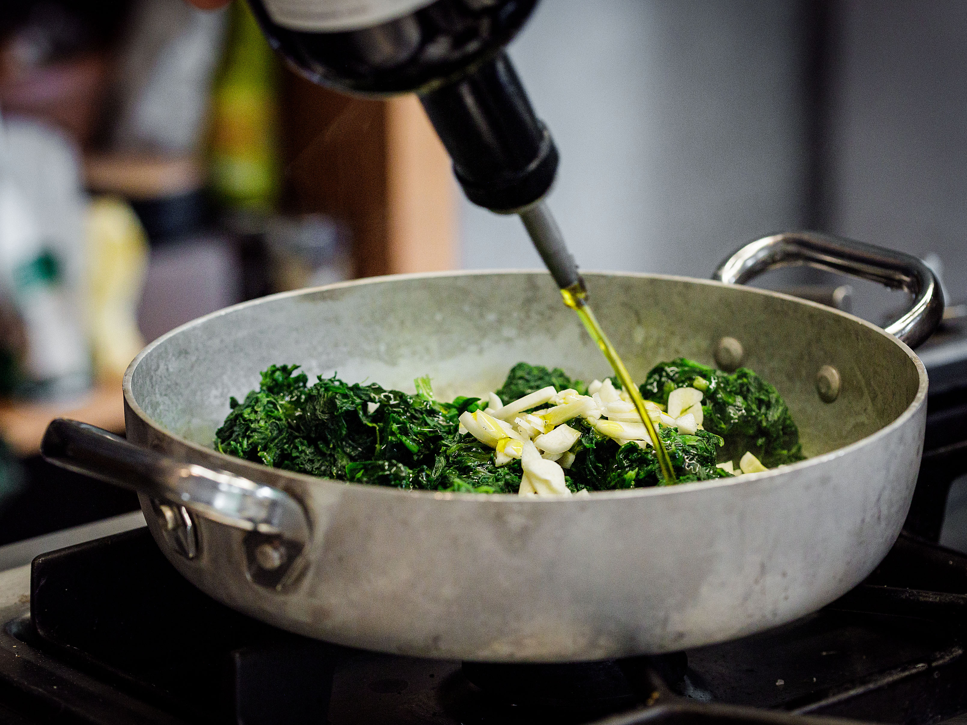 Schritt 1: Den Spinat mit der Minze, dem Knoblauch und einem Schuss Olivenöl in einer grossen Pfanne mit Deckel kurz dünsten