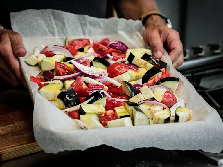 Schritt 2: Das Gemüse auf einem grossen, mit Backpapier ausgelegtem Backblech verteilen und mit dem zusätzlichen Olivenöl überziehen Schritt 2: Das Gemüse auf einem grossen, mit Backpapier ausgelegtem Backblech verteilen und mit dem zusätzlichen Olivenöl überziehen