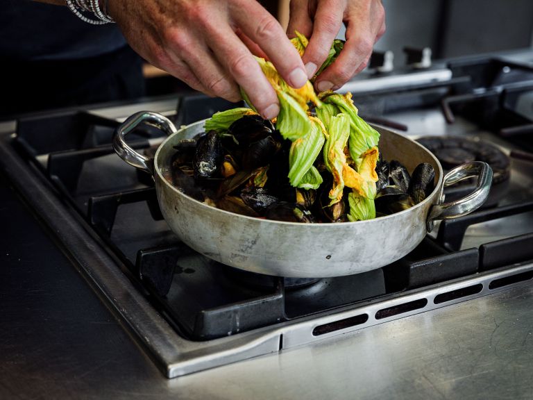 Schritt 4: Zum Servieren Petersilie und Zucchiniblüten untermischen und abschmecken