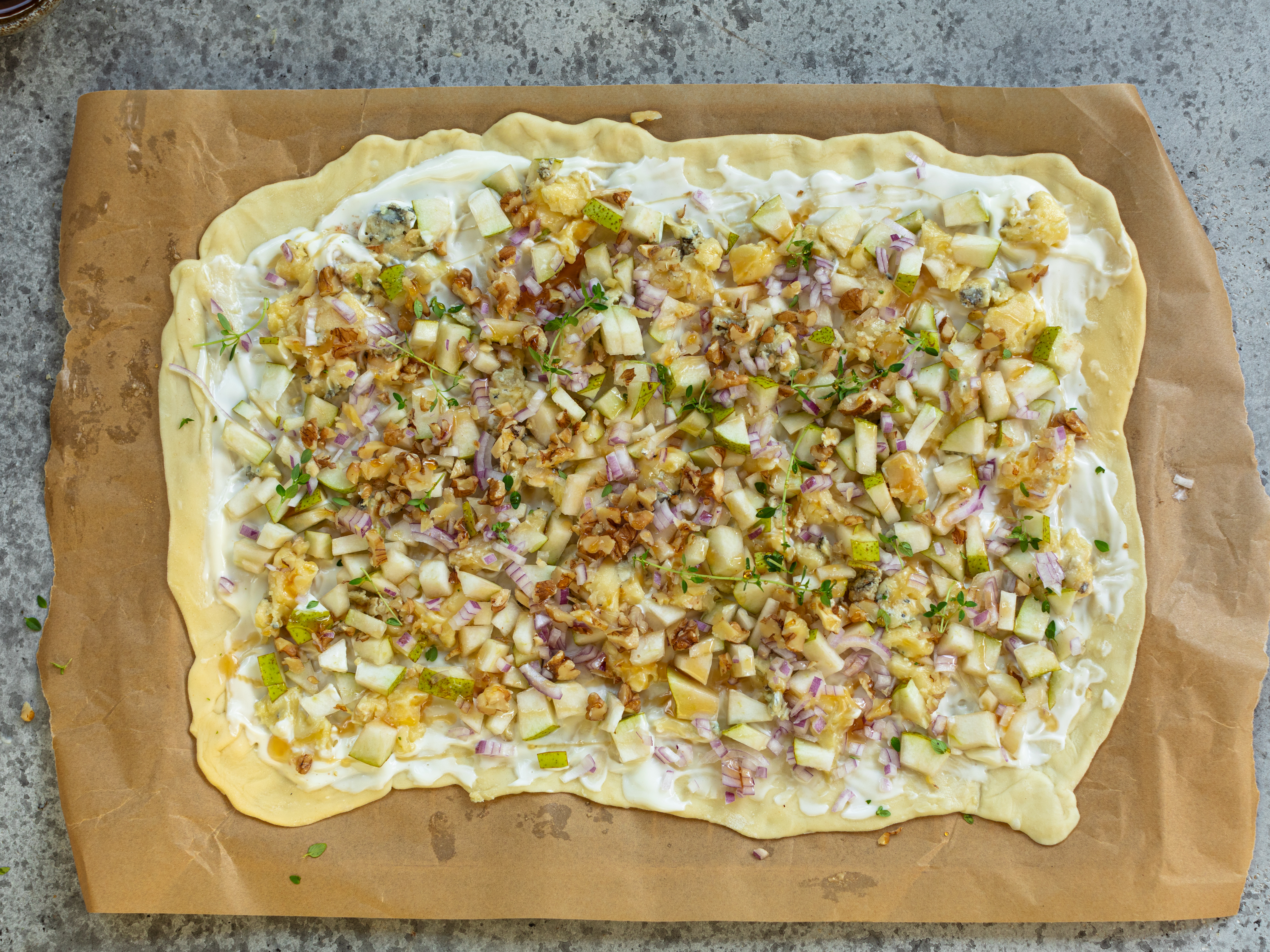 Schritt 2:  Birnen- und Zwiebelwürfel auf der Creme verteilen