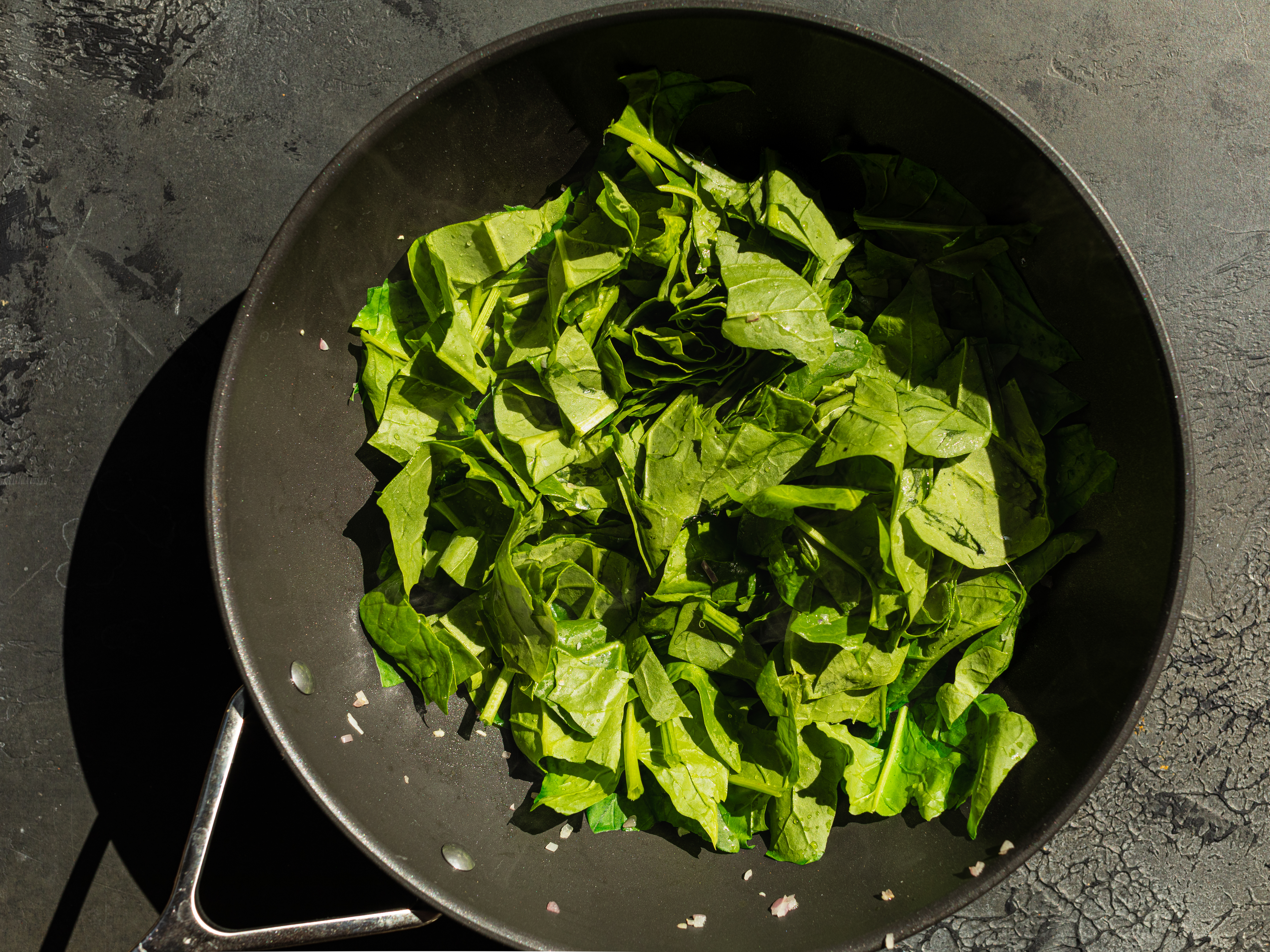Schritt 2: Den frischen Spinat hinzufügen und kurz anbraten, bis er zusammenfällt