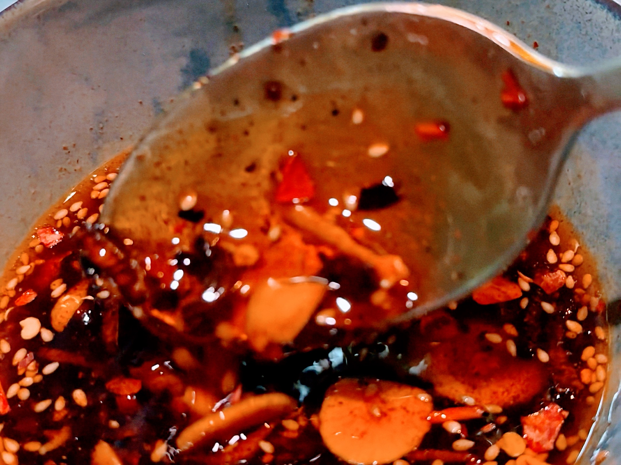 Schritt 3: Das Öl abkühlen lassen, die Gewürzzutaten, die frittierten Zutaten und die Sesamsamen hinzufügen