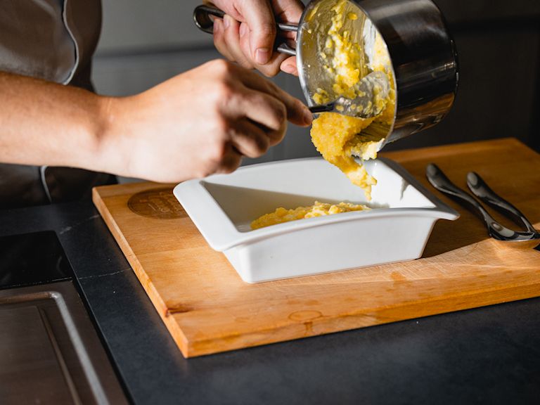 Schritt 1: Eine Auflaufform (ca. 20x20 cm) mit etwas Olivenöl einfetten und die Polenta hineingeben und glattstreichen. Schritt 1: Eine Auflaufform (ca. 20x20 cm) mit etwas Olivenöl einfetten und die Polenta hineingeben und glattstreichen.