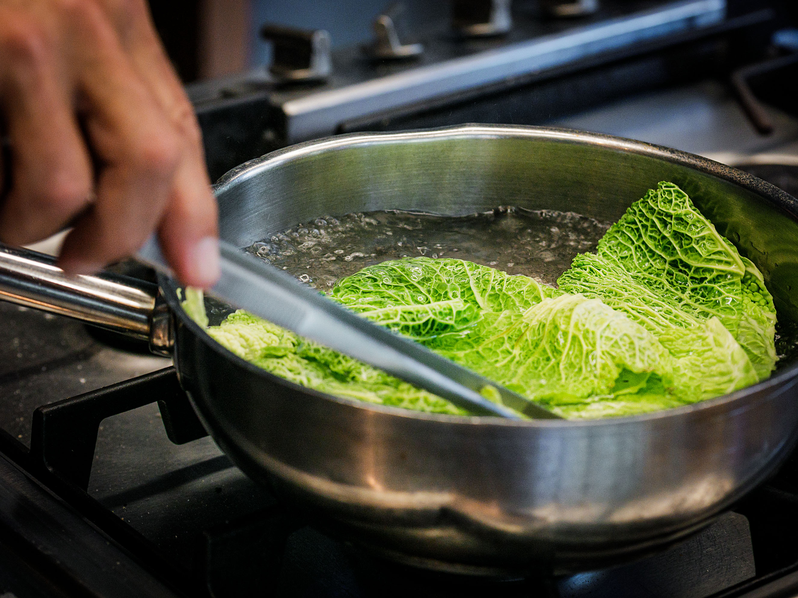 Schritt 1: Die Kohlblätter etwa 20 Sekunden lang in kochendem Salzwasser blanchieren 