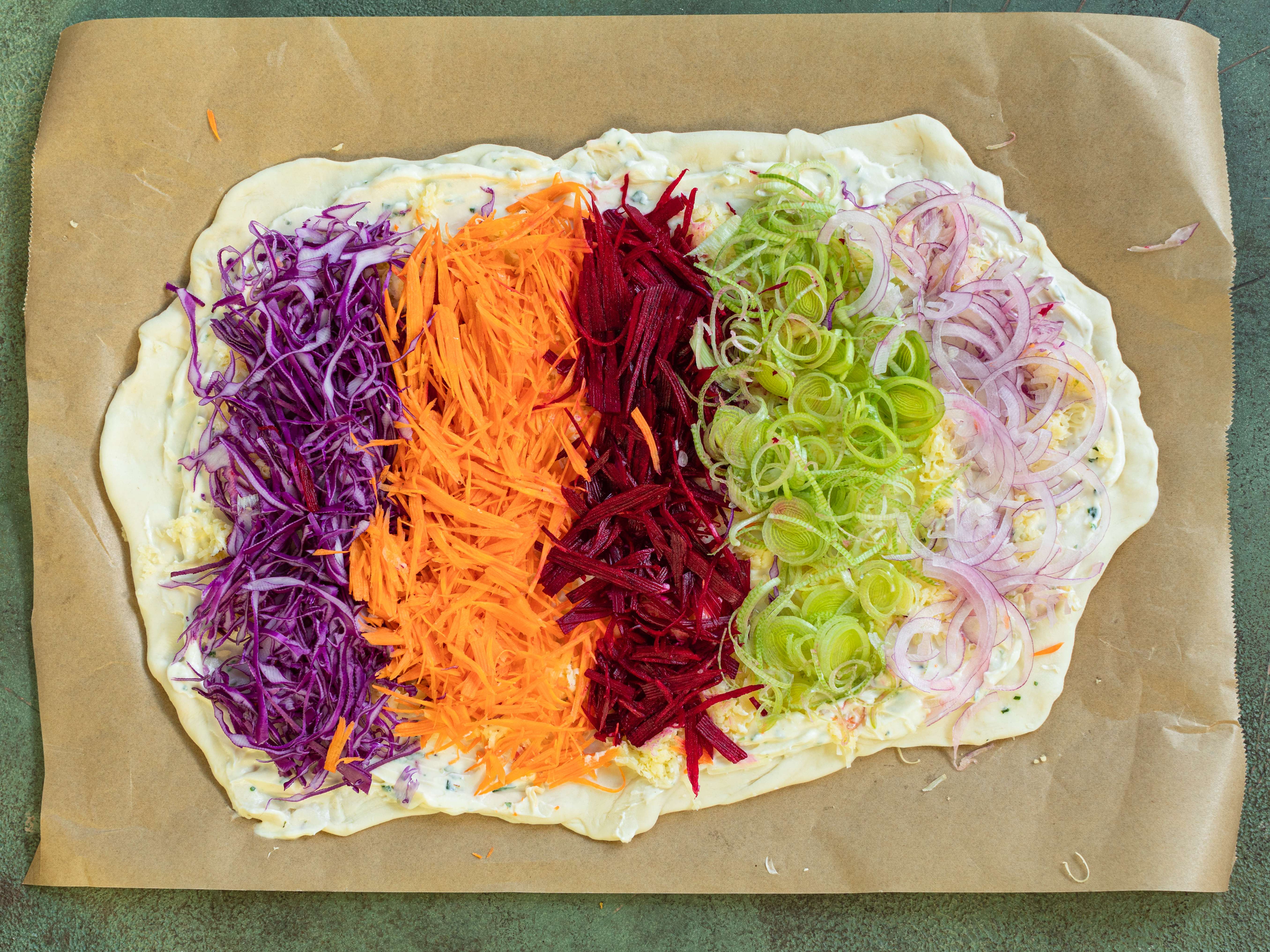 Schritt 4: Die vorbereiteten Gemüsesorten in einem Regenbogenmuster auf den Teigen anordnen