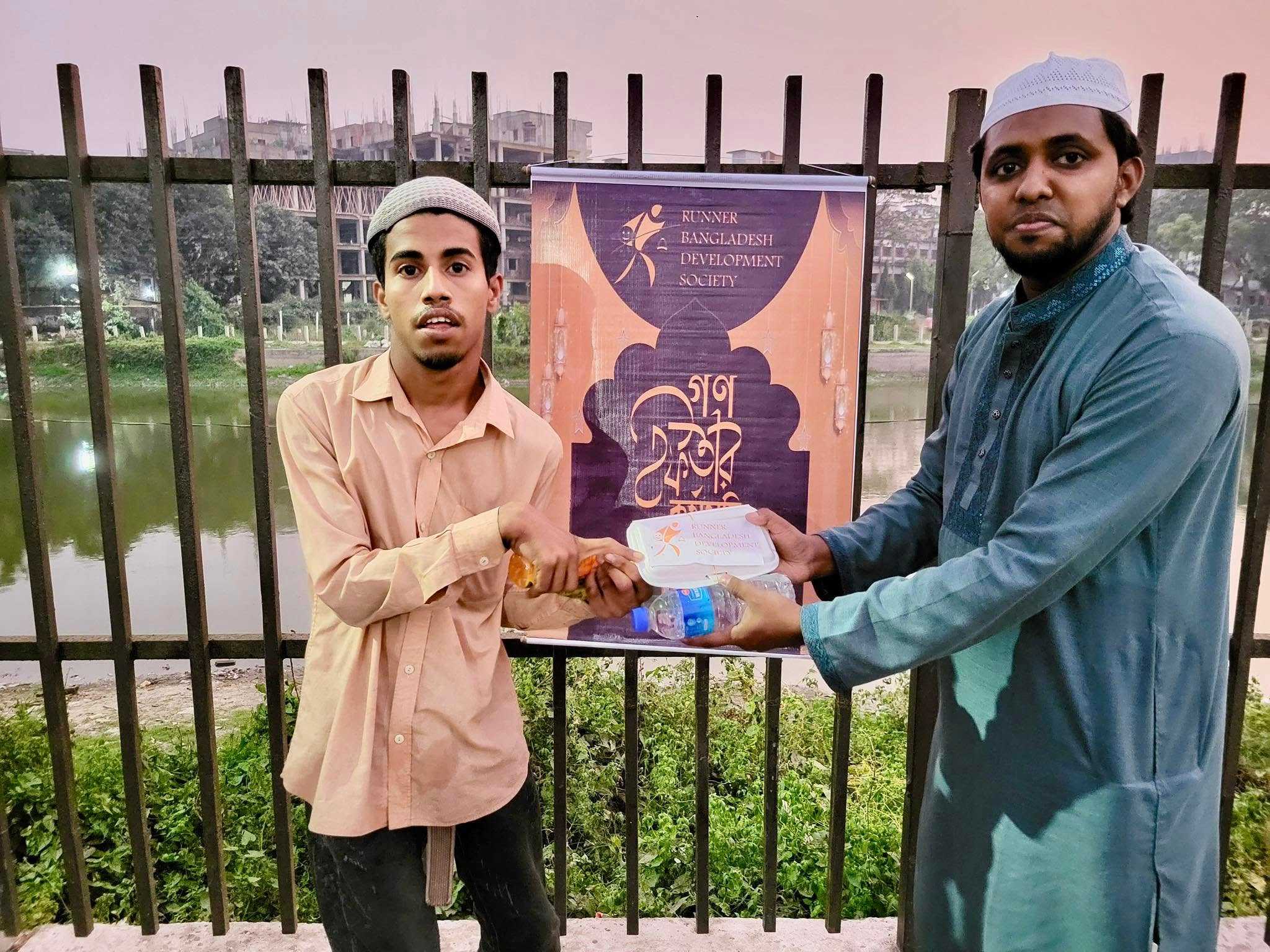 A young man receives an Iftar meal, reflecting the spirit of generosity and unity in the community.