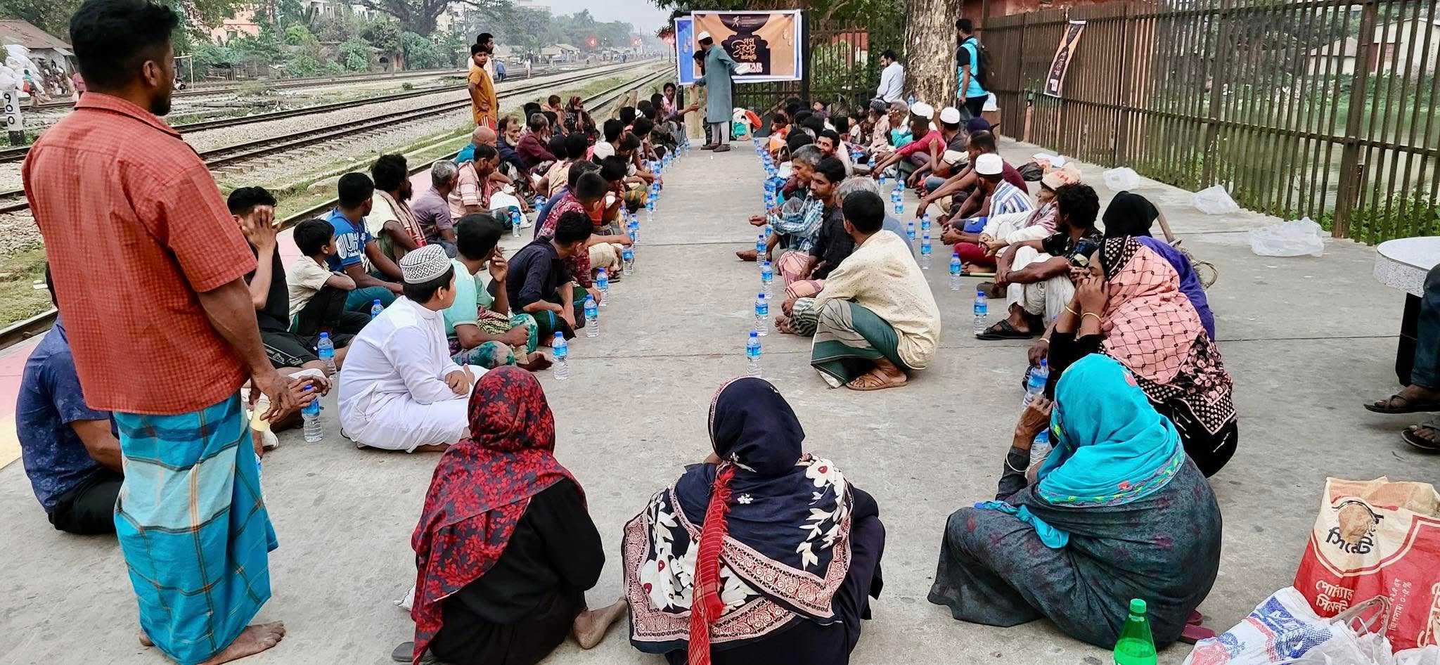 People gather in rows, ready to break their fast at a mass Iftar event organised by Runner Bangladesh Development Society.