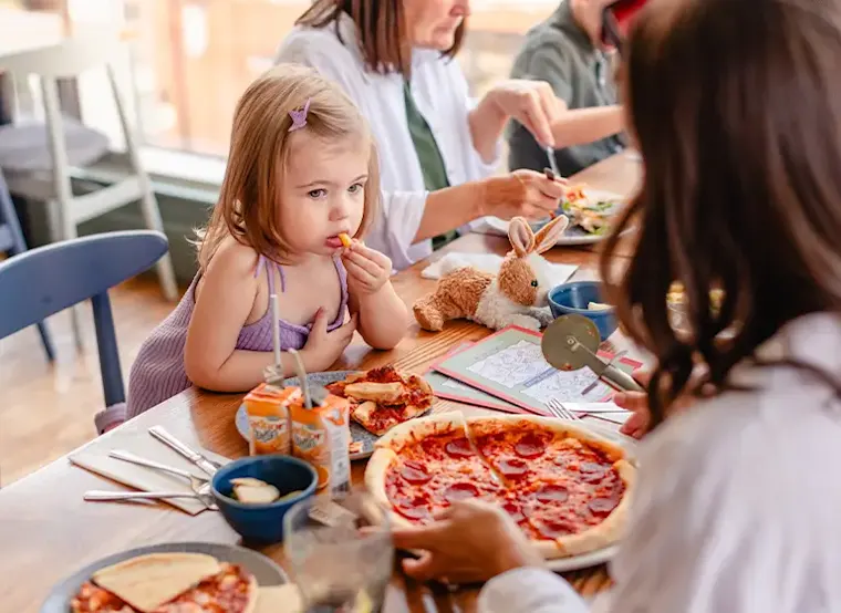 A child enjoying a pizza and sides as part of Bella Italia-s Kids Eat Free deal