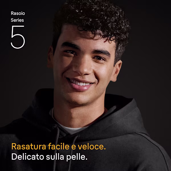 Giovane uomo sorridente con capelli neri ricci che indossa una felpa con cappuccio nera.