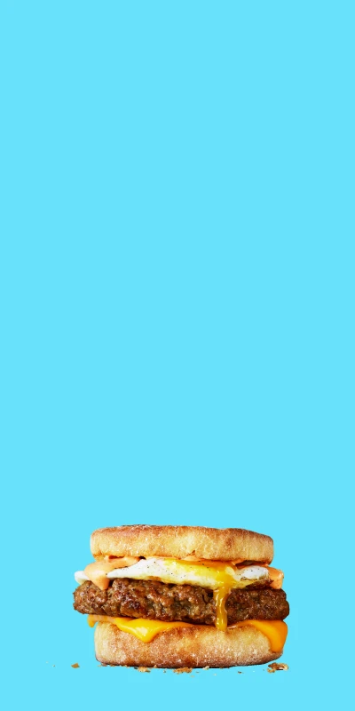 Impossible sausage food items stacked on top of one another on blue background