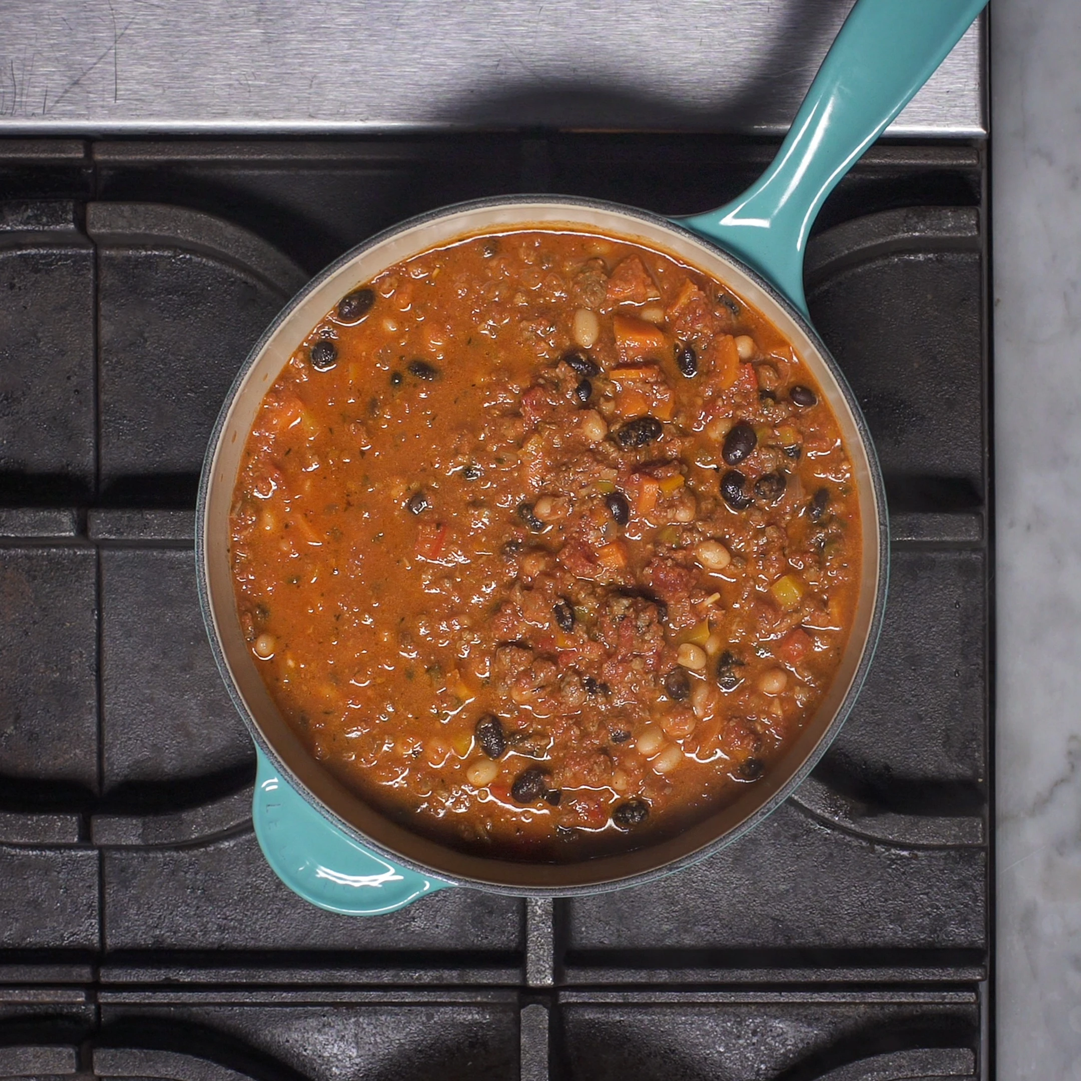 Image of chili made with Impossible burger cooking on the stove in a big pot