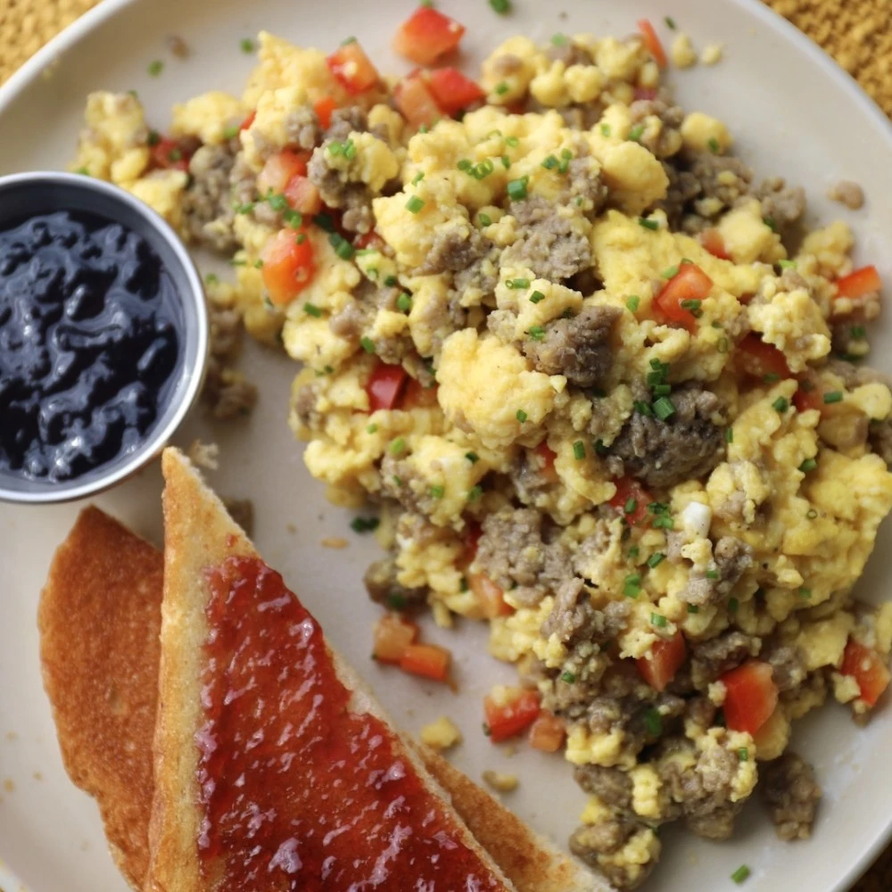Impossible Savory Sausage scramble with tomatoes and chives, served with toast and jam. 